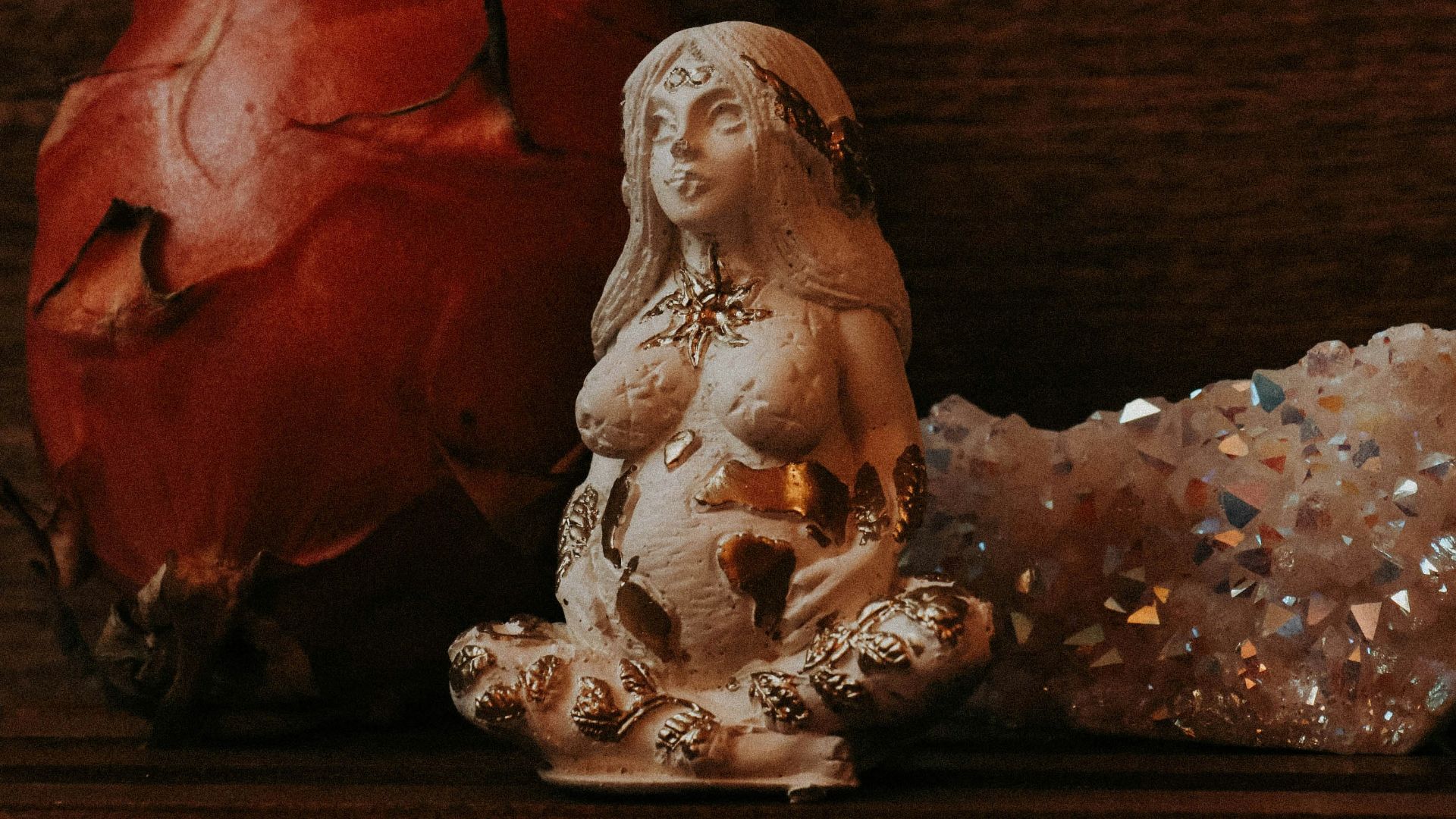 a statue of a woman sitting next to a rock