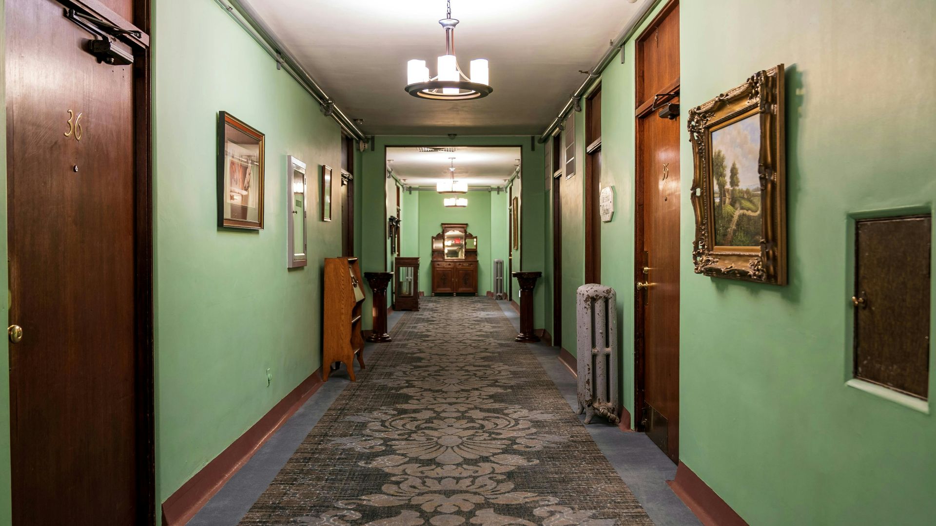 A long hallway with a carpeted floor and green walls