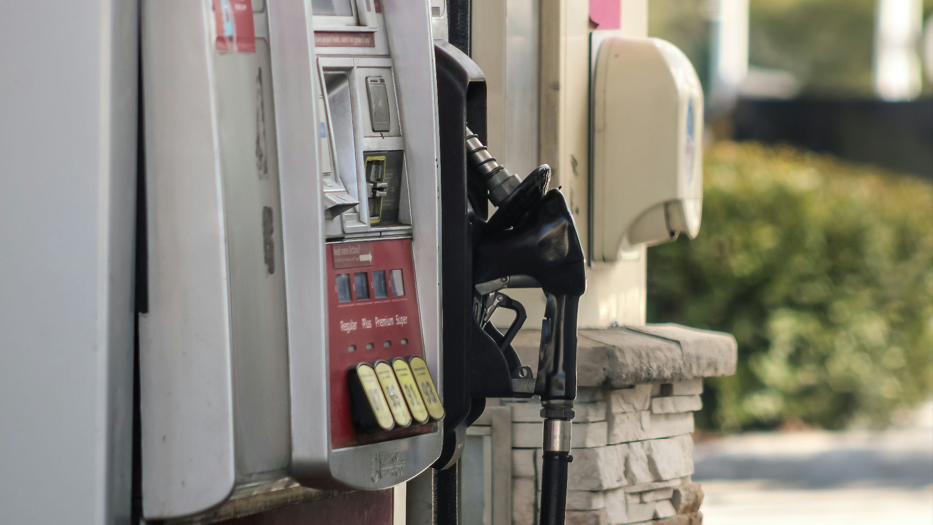 a gas pump next to a brick wall