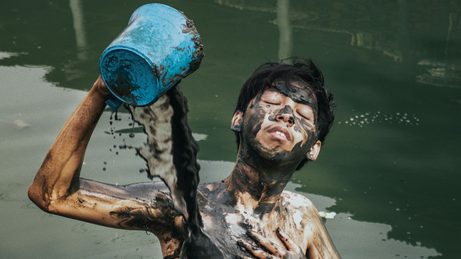 a man is in the water with a bucket on his head