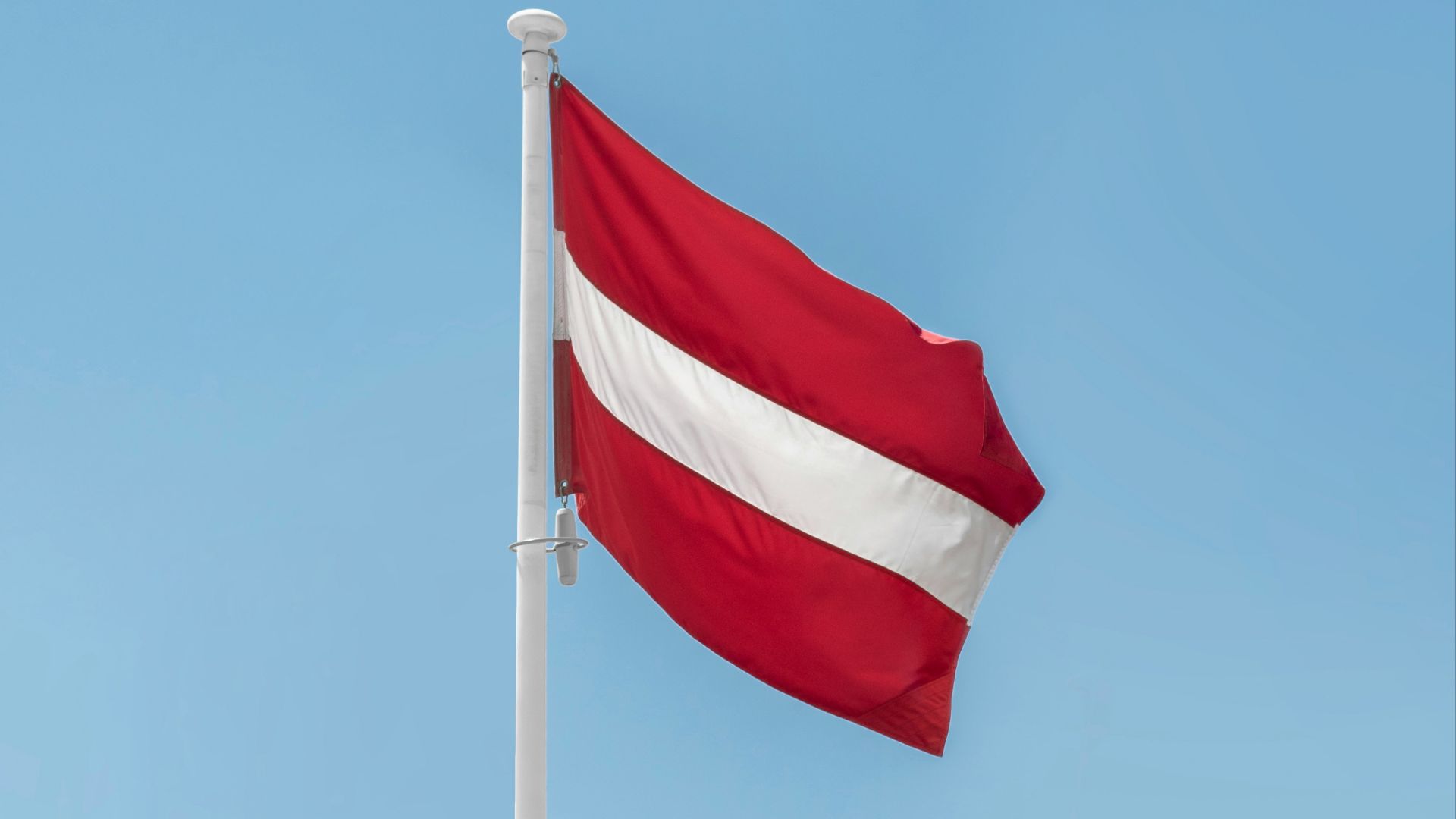 a red and white flag on a flagpole