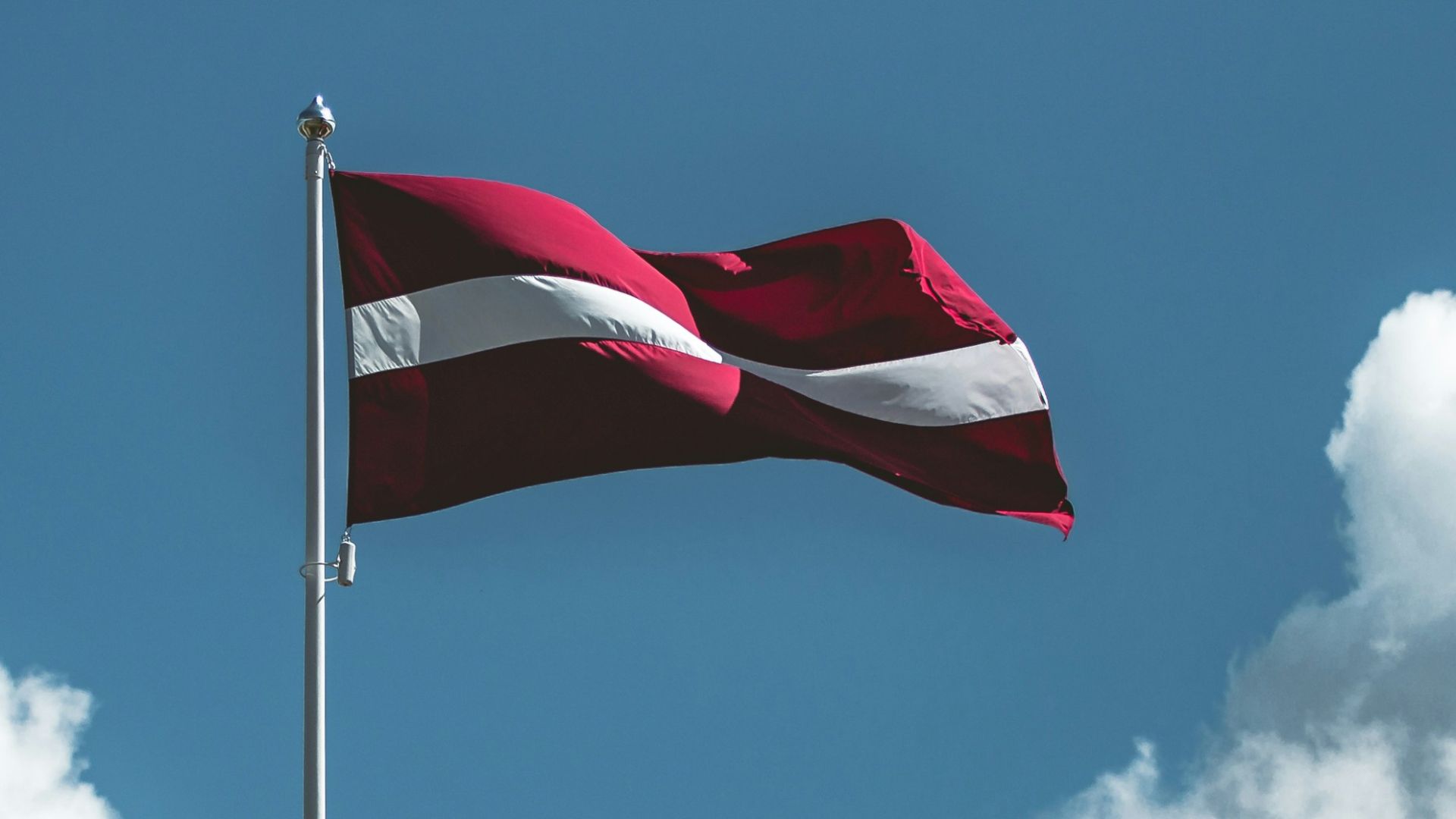 waving red and white striped flag on pole