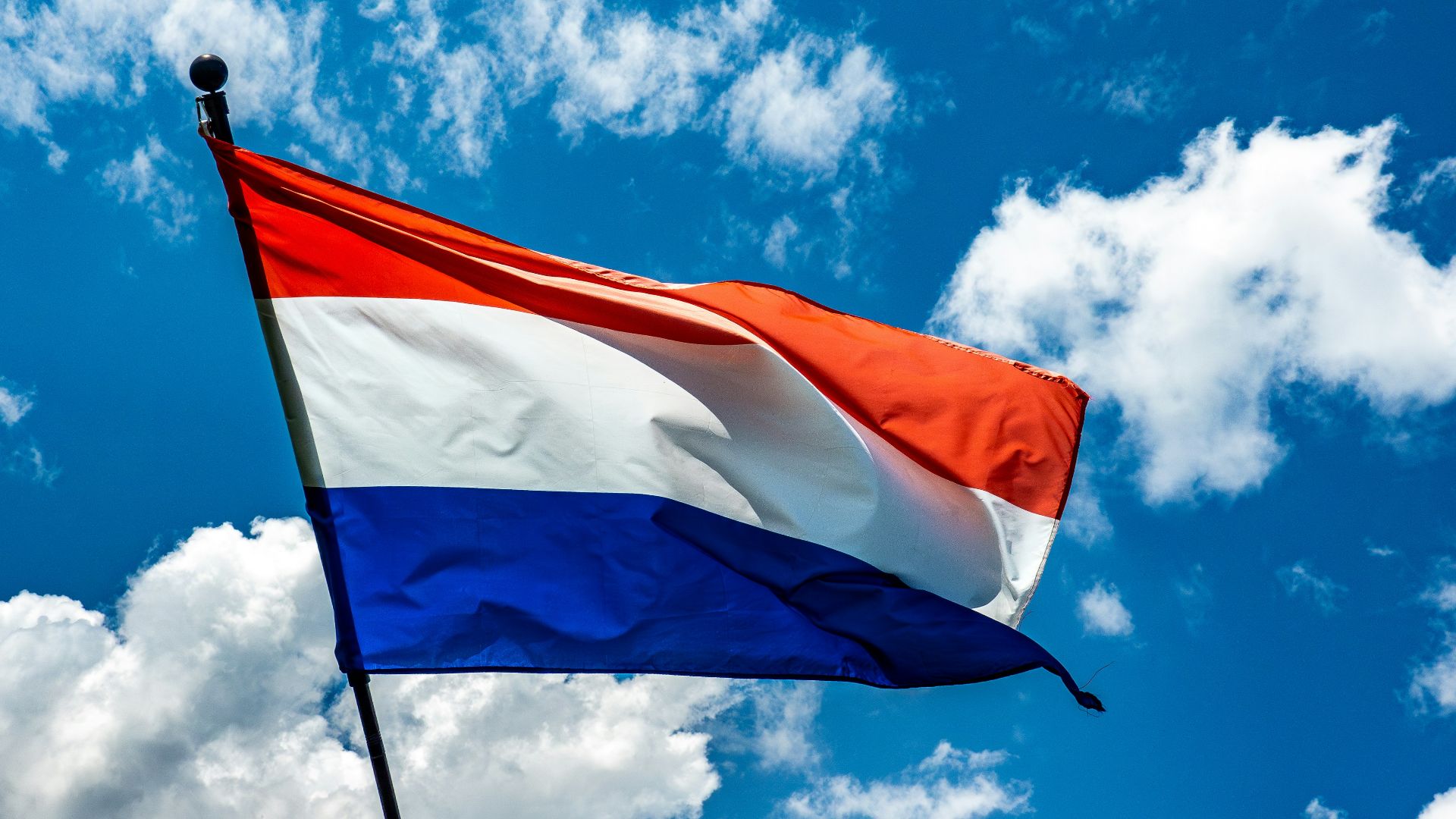 A red white and blue flag flying in the sky