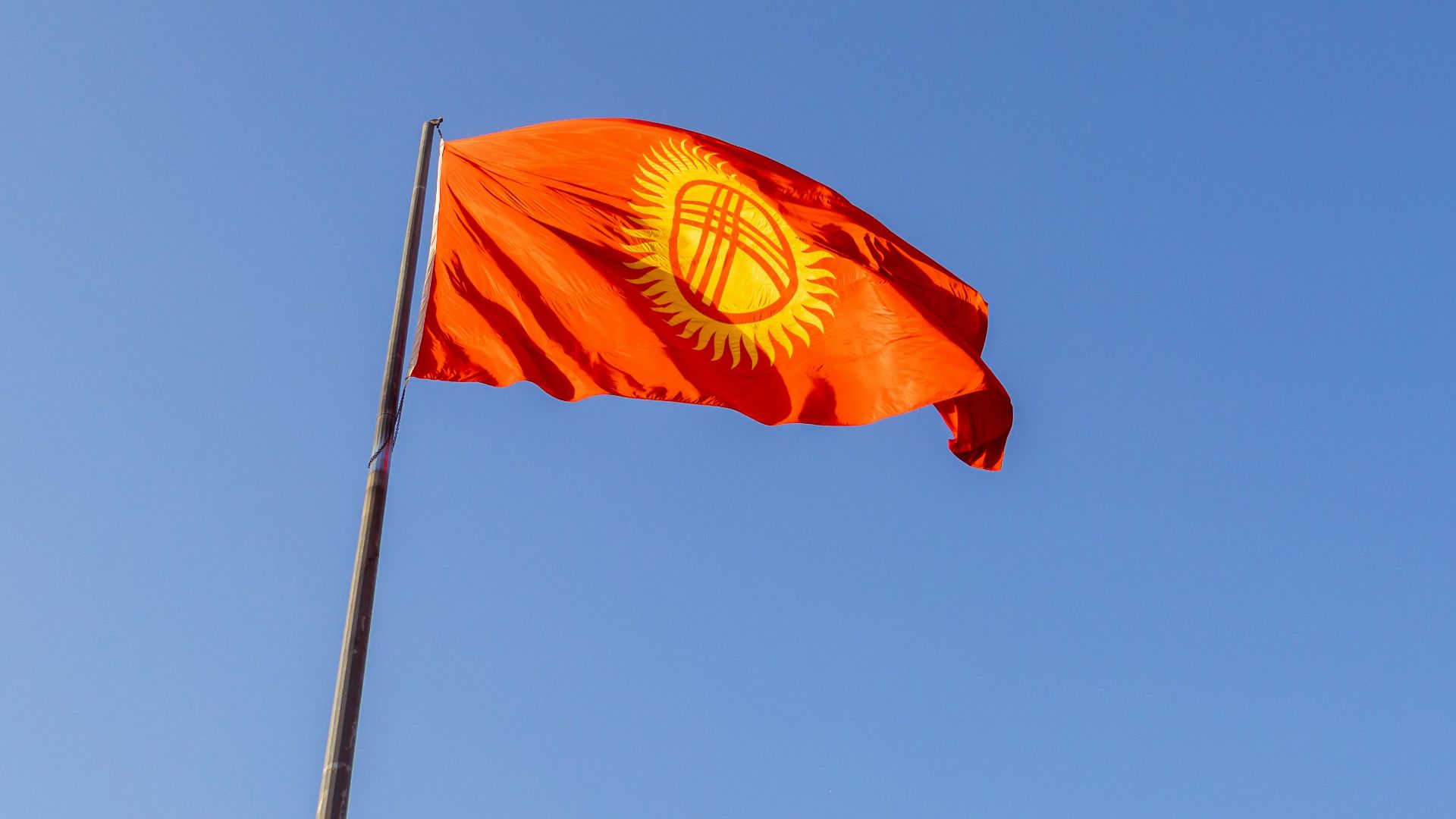 a red flag flying in the wind on a clear day