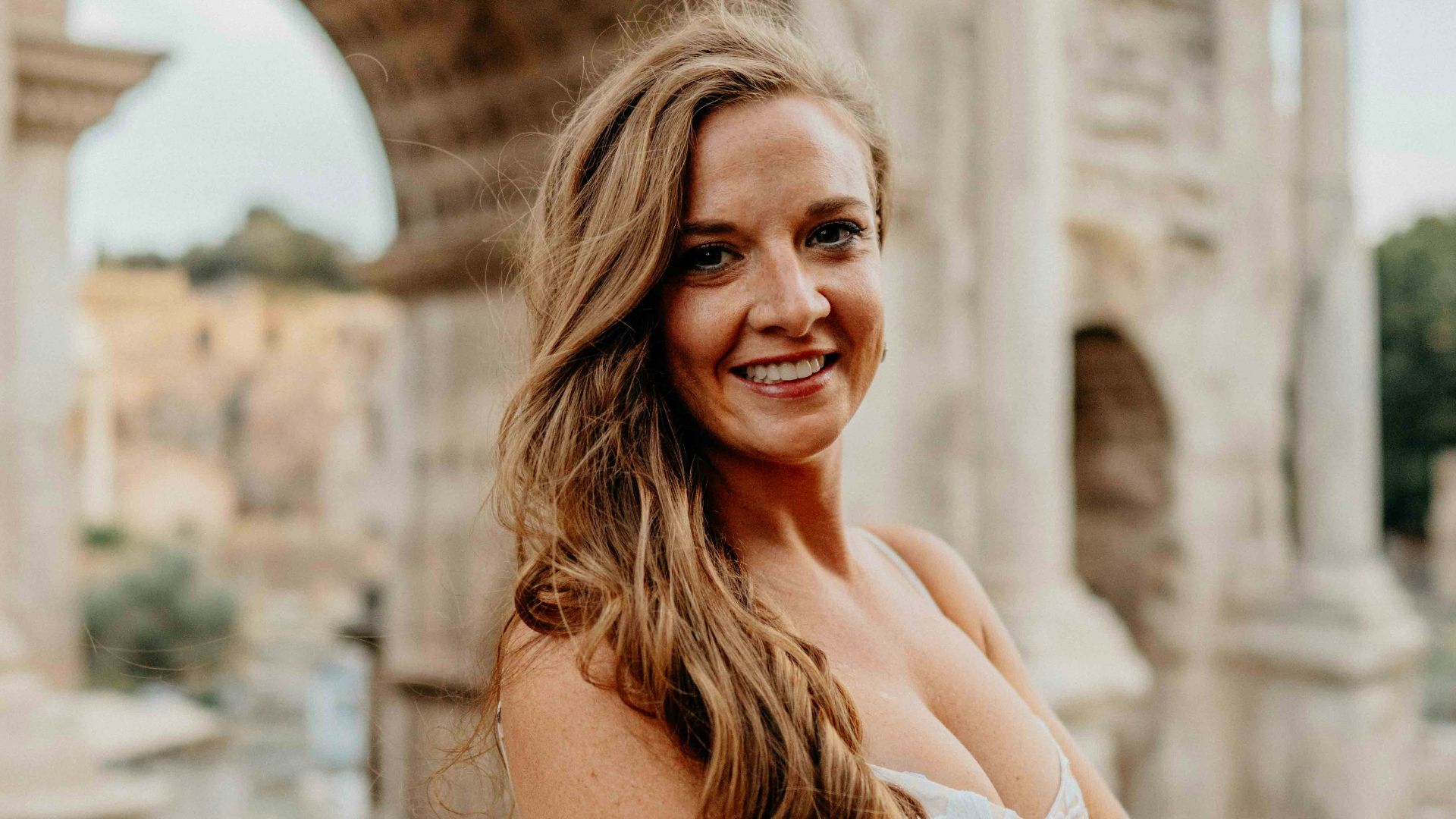 a woman standing in front of an arch of triumph