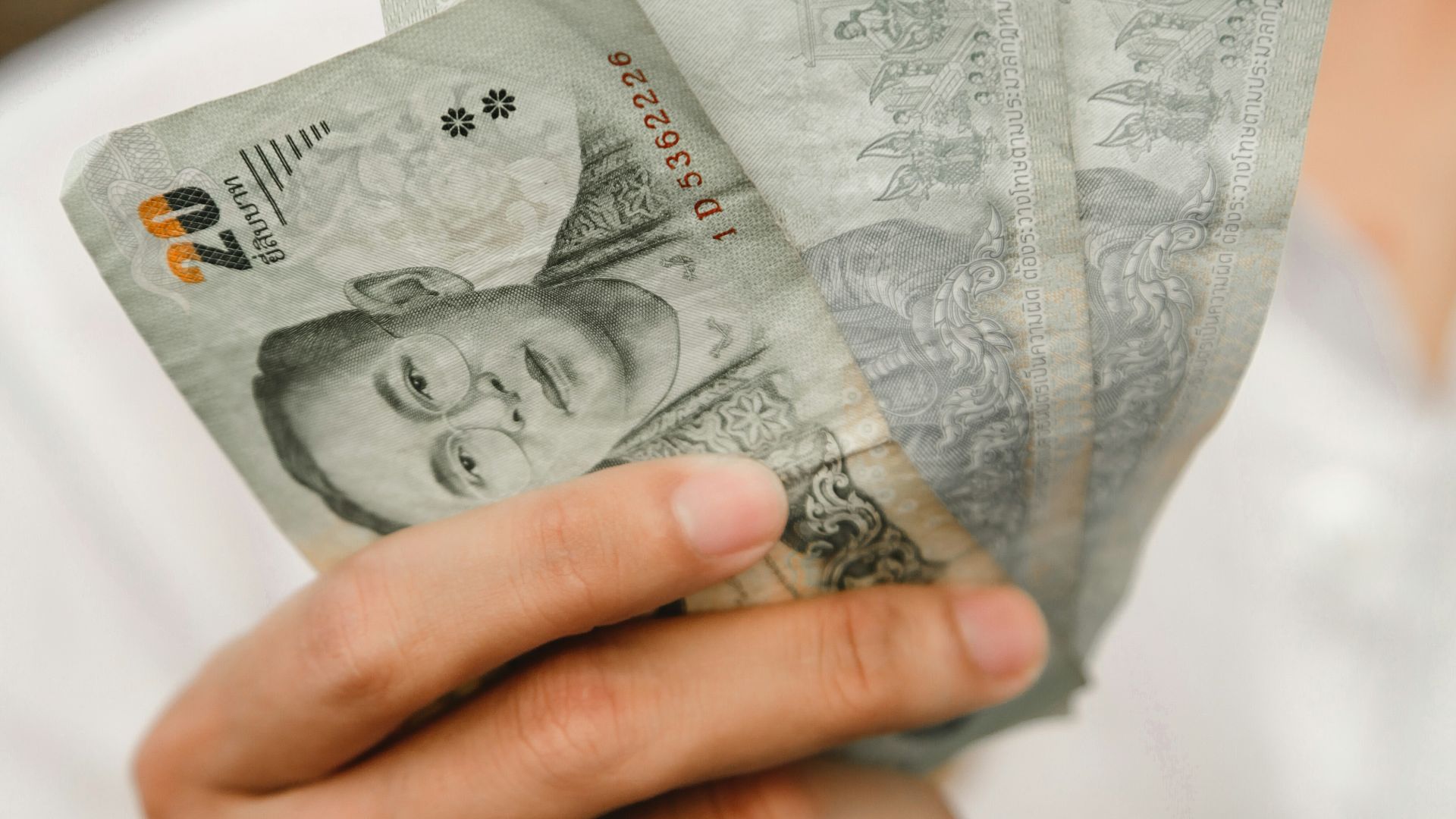 a person holding a stack of paper money