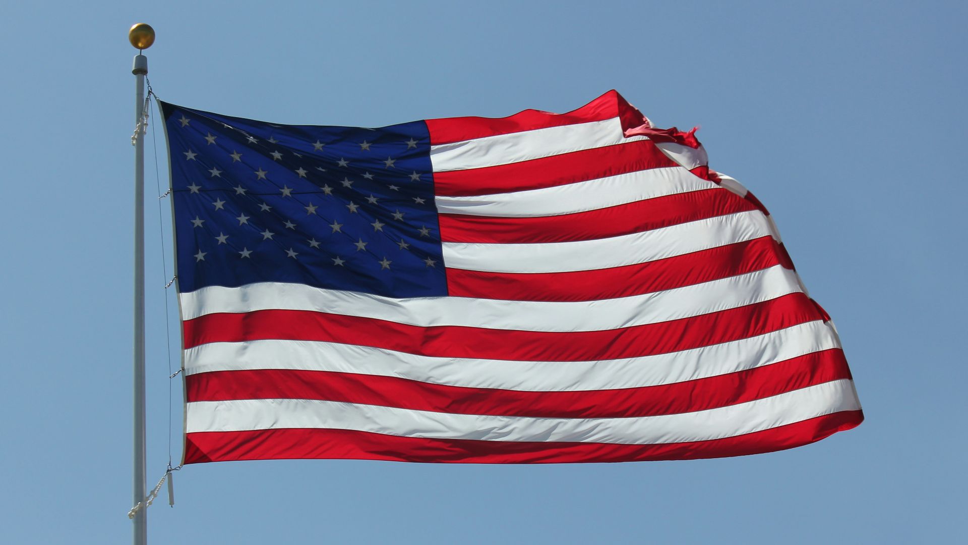a large american flag flying in the sky