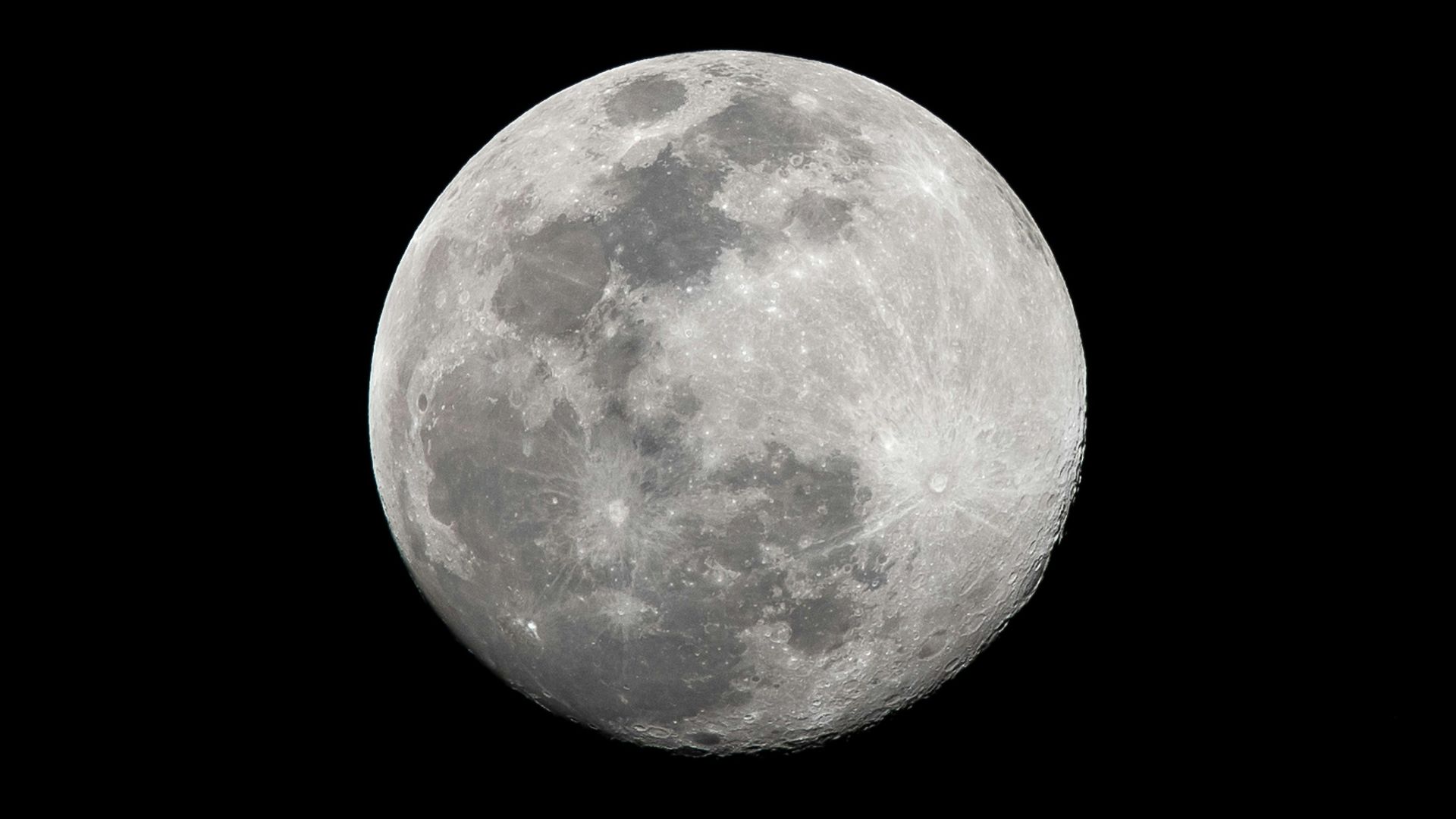 a full moon is seen in the dark sky