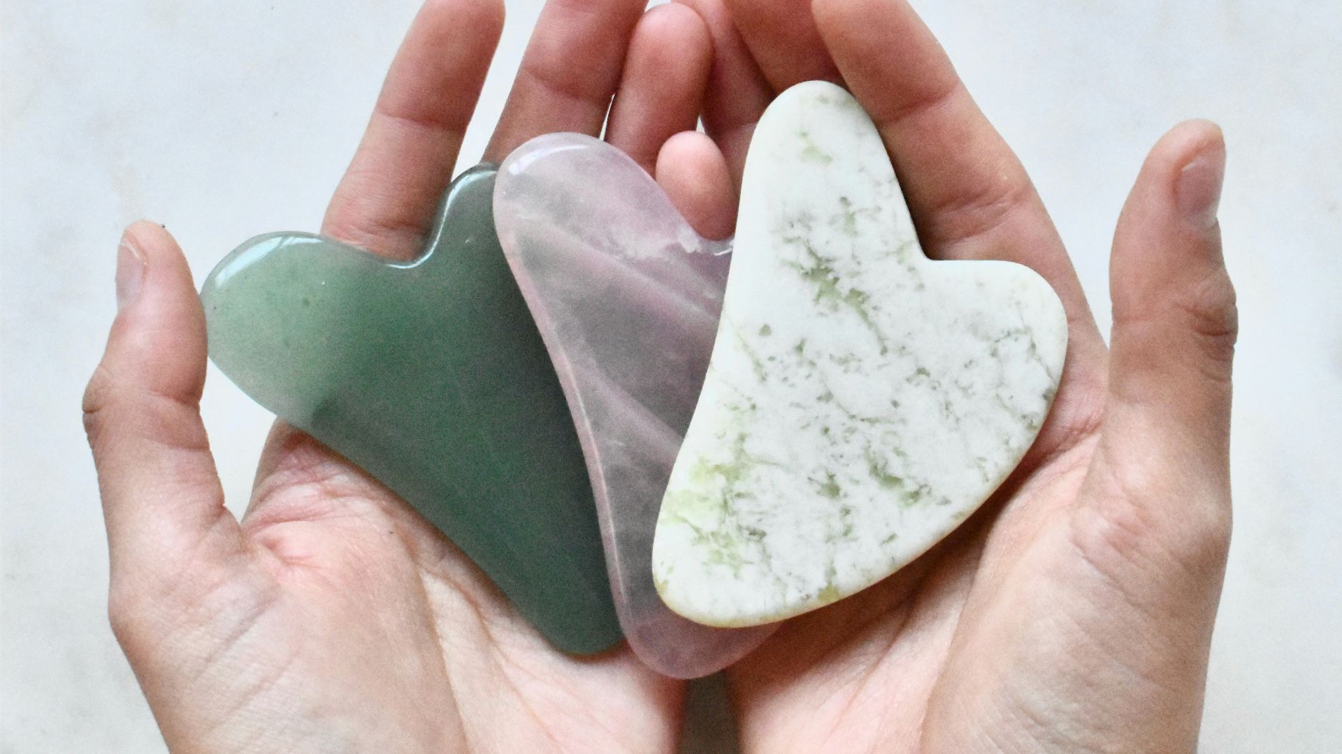two hands holding two heart shaped pieces of soap