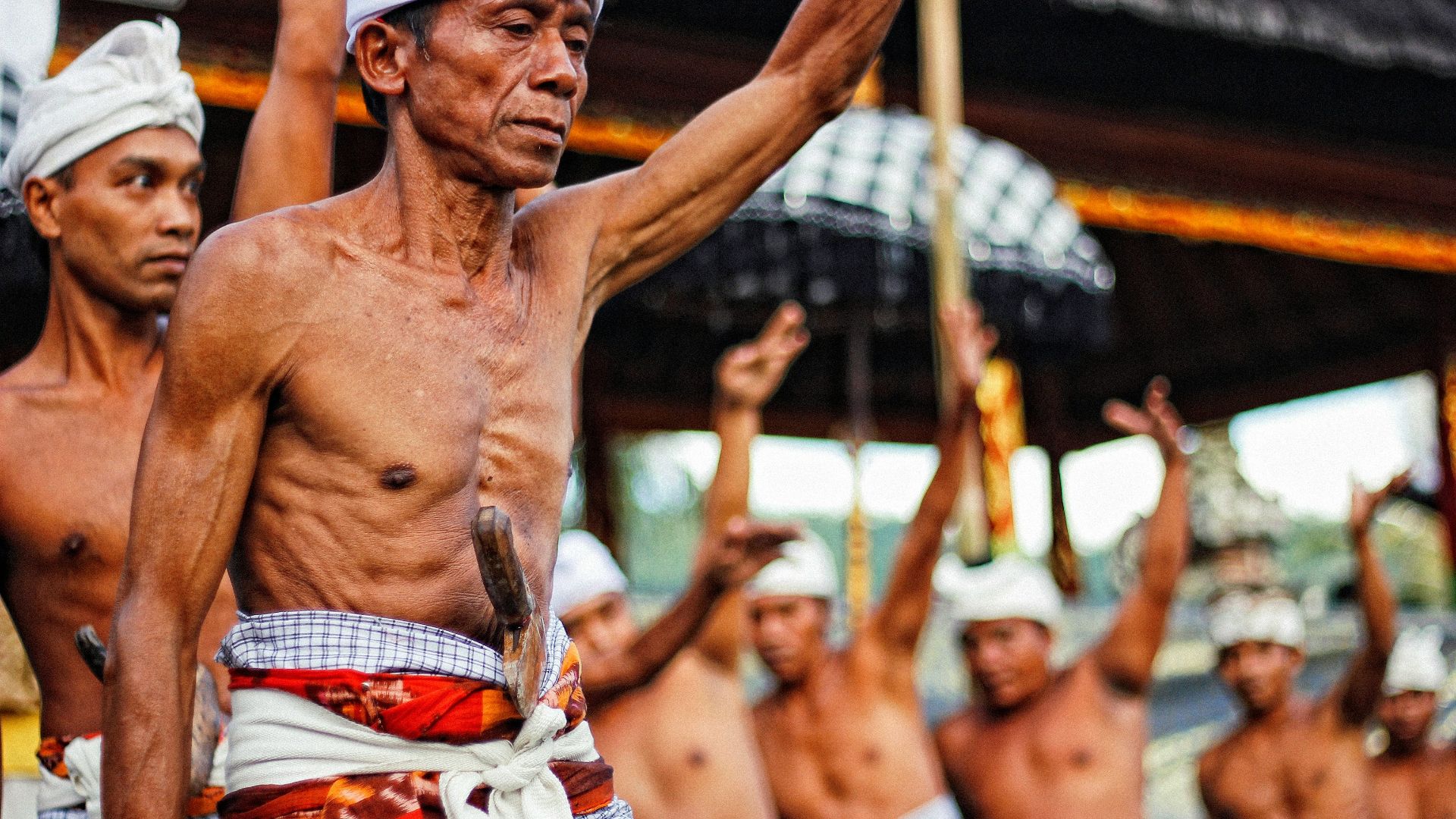 man with knife on stomach raising hands