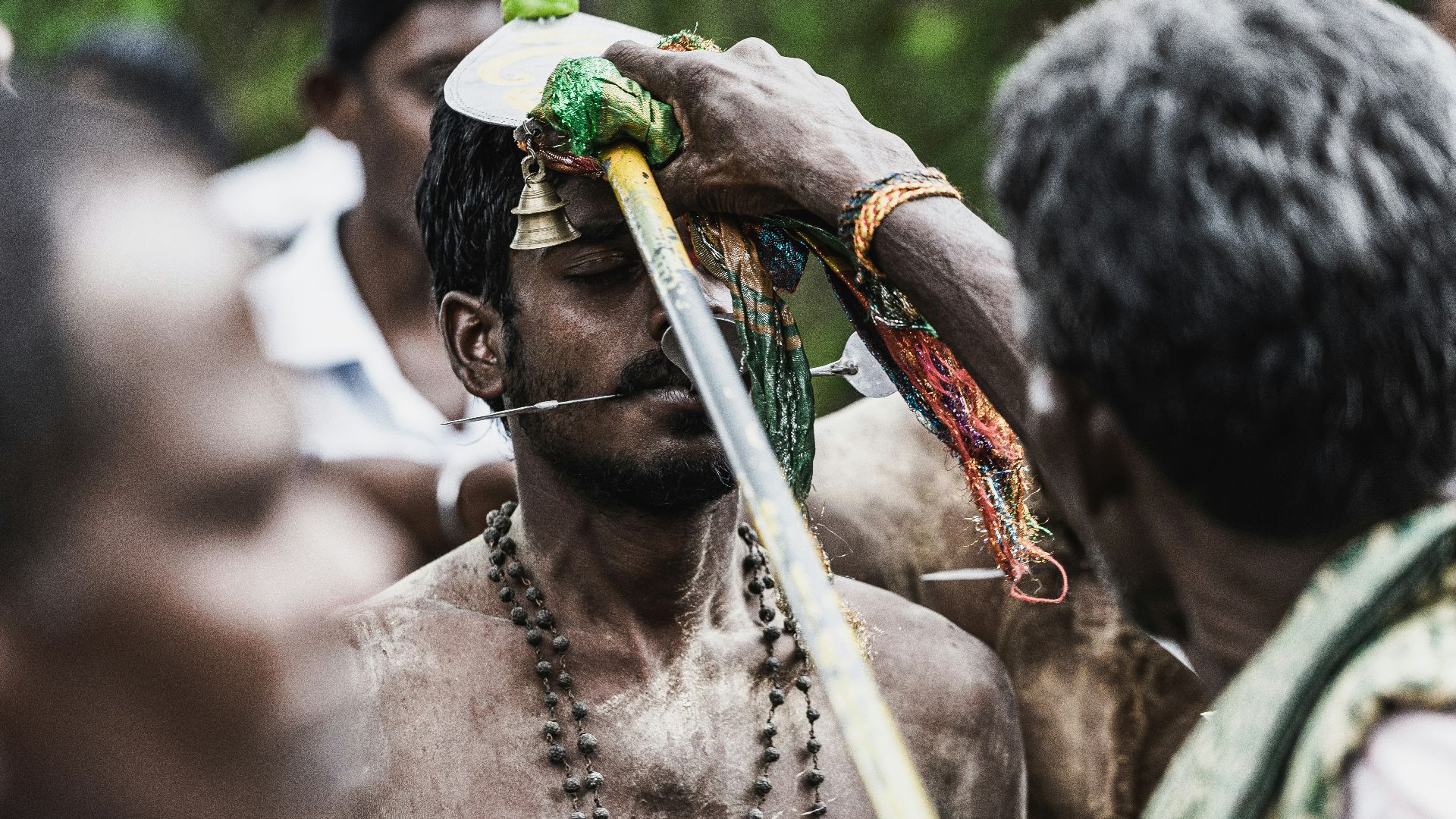 man in green and brown hat holding white stick