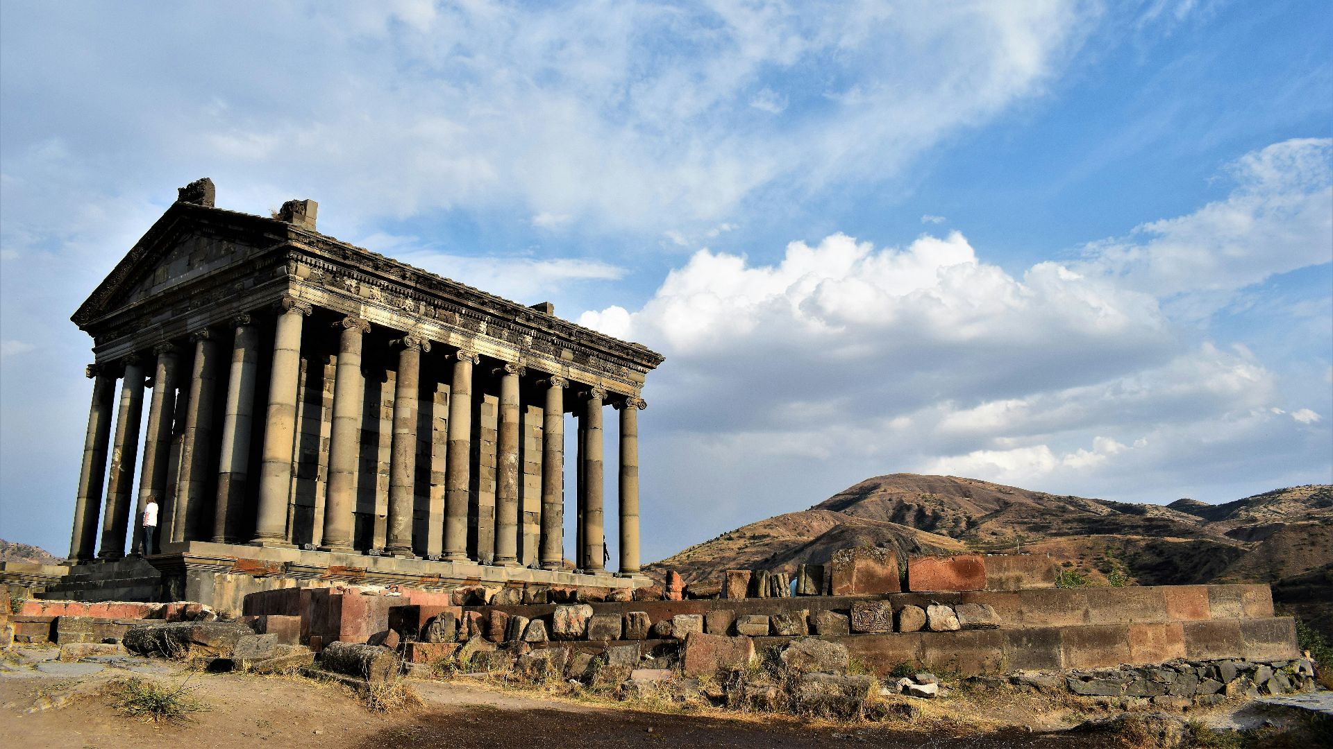brown concrete building under white clouds during daytime