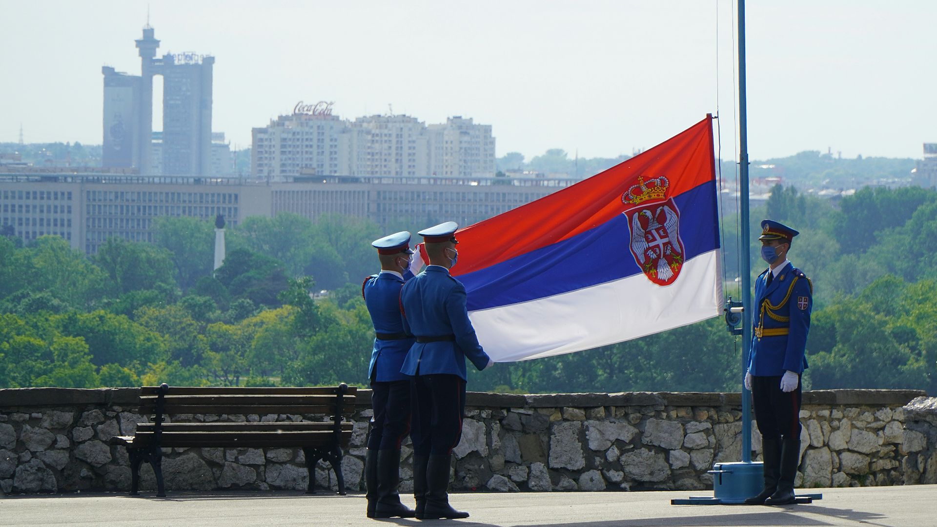 man in black jacket standing near flag of us a during daytime