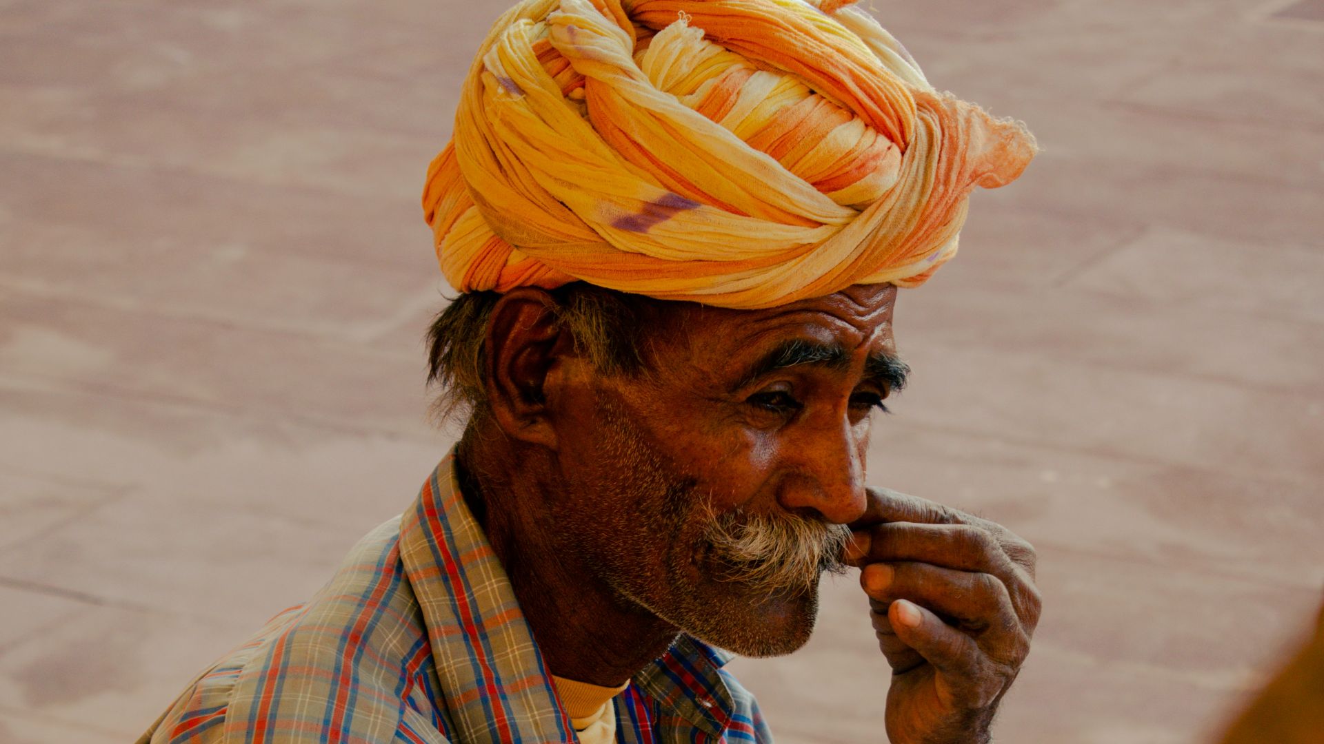 A man with a turban on his head smoking a cigarette