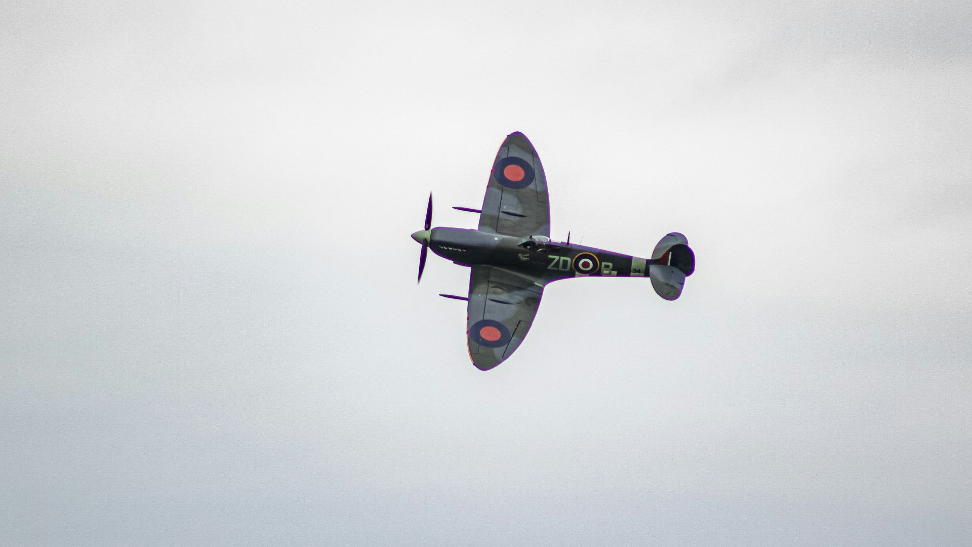 A plane flying in the sky over a field