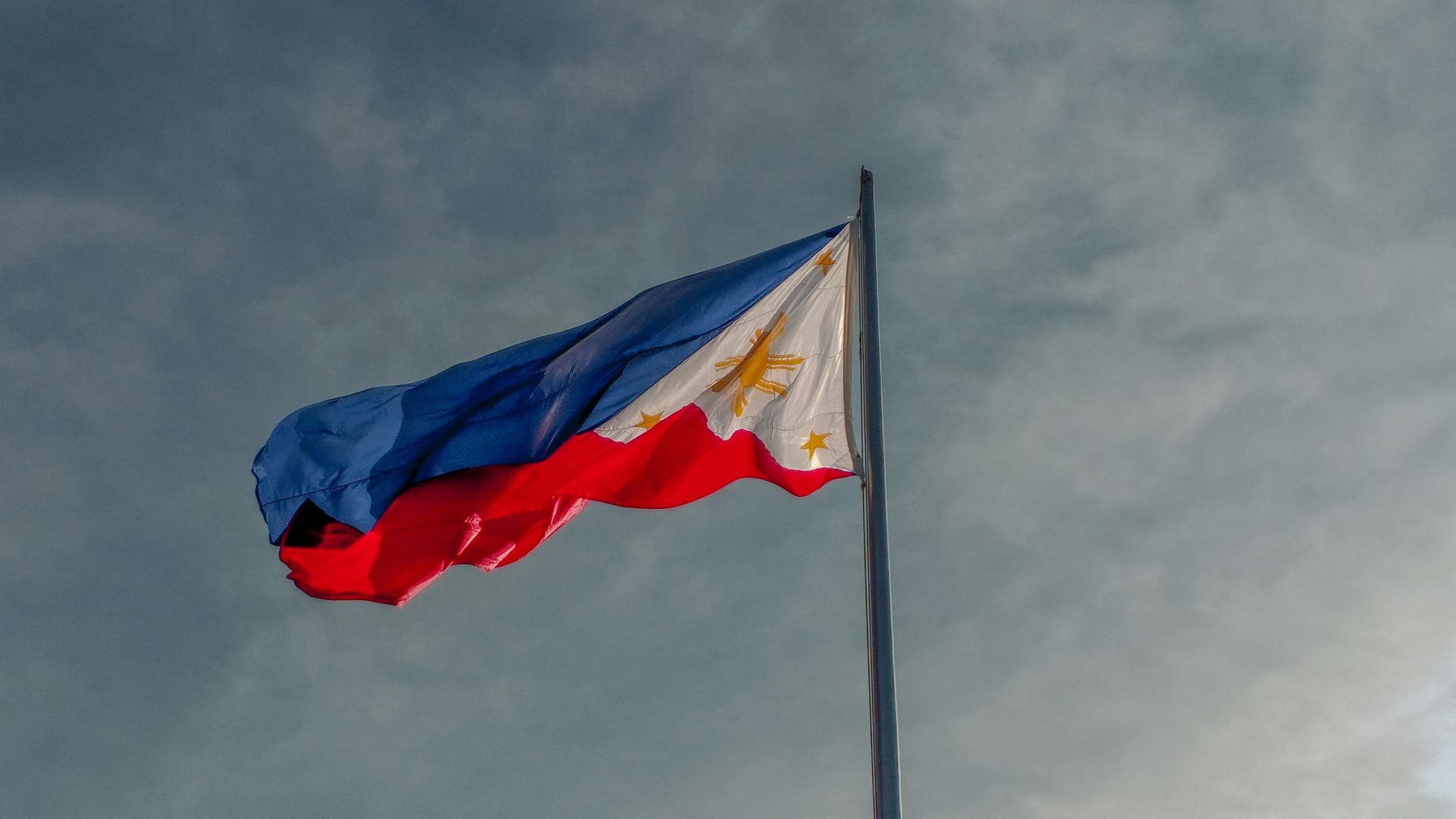 a flag flying in the wind on a cloudy day