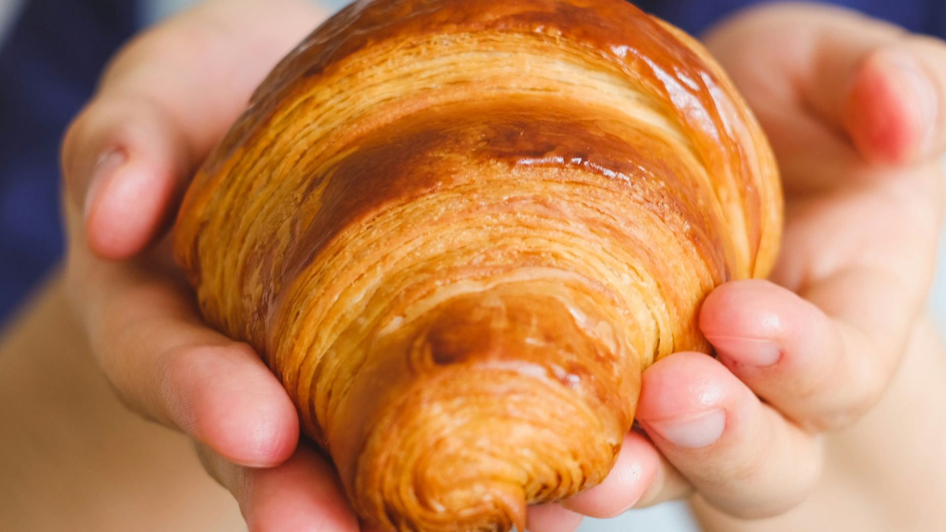 a woman holding a pastry in her hands