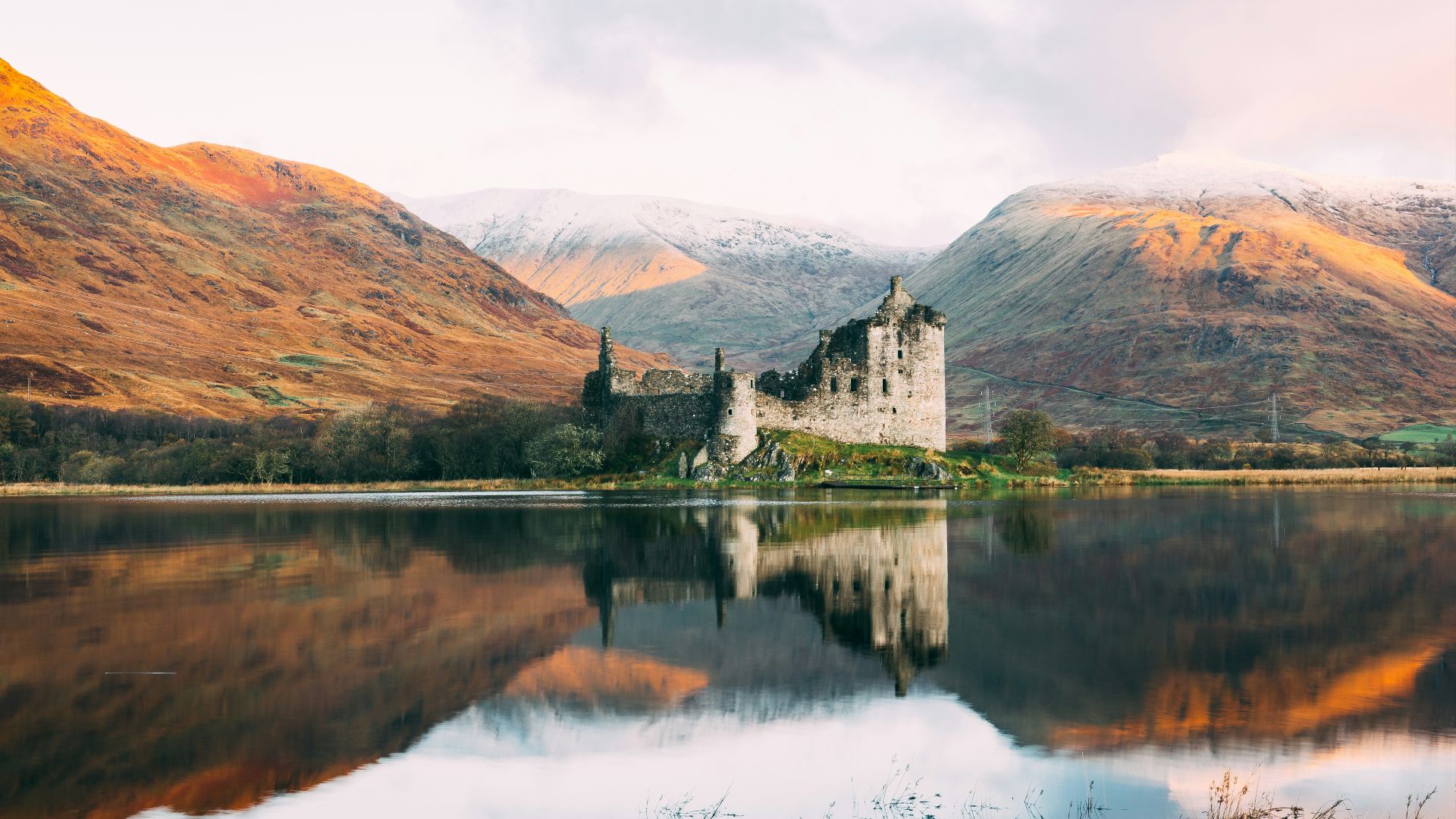 gray concrete building near lake under white sky during daytime