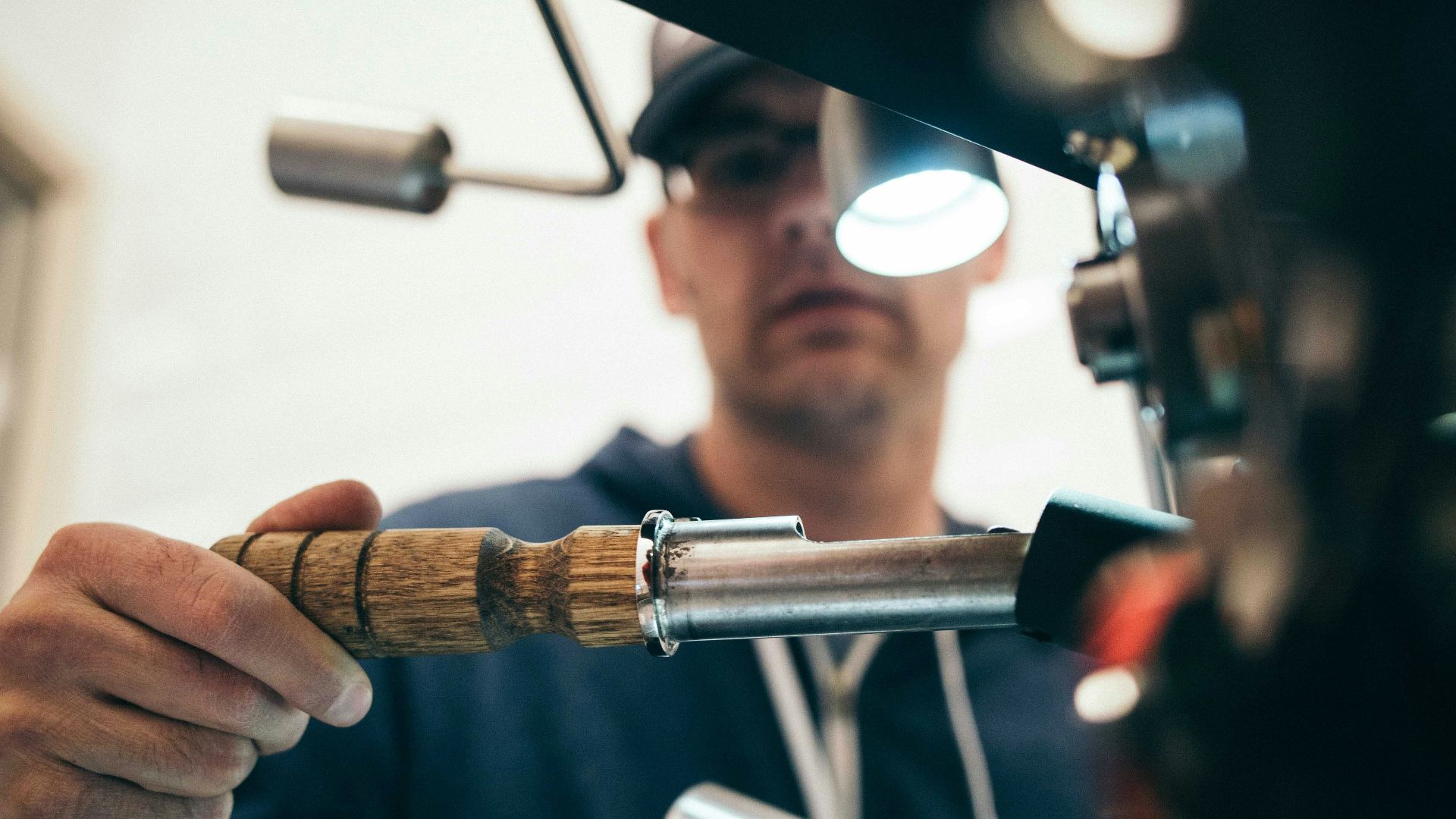 man wearing black pullover hoodie holding tool