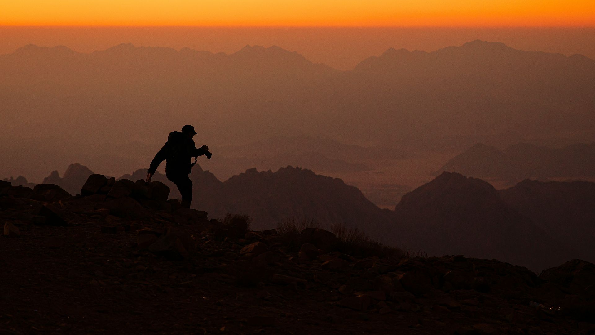 a person standing on top of a mountain at sunset