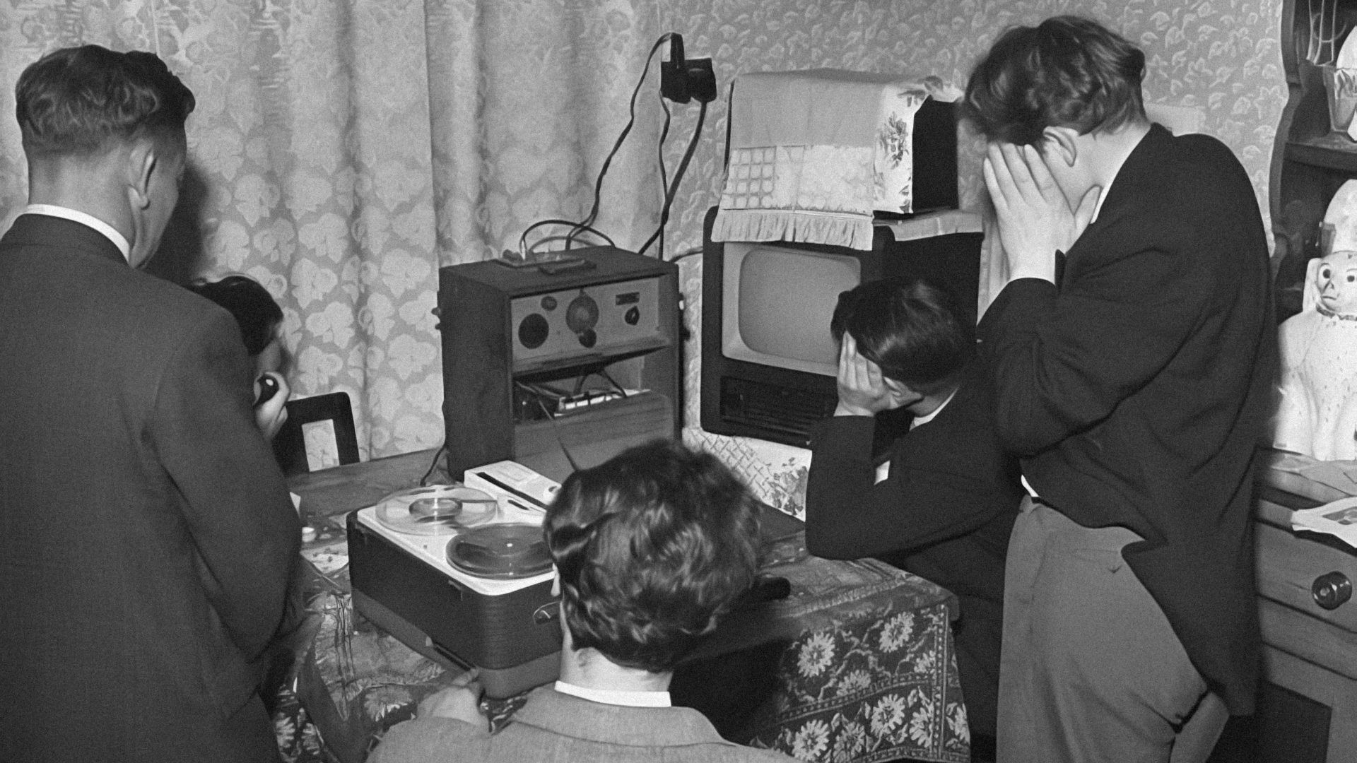 a black and white photo of people in a living room