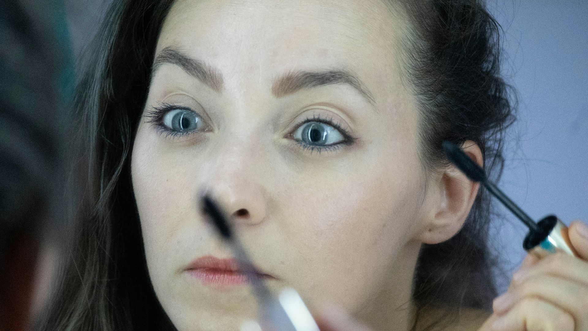 a woman is doing makeup on her face