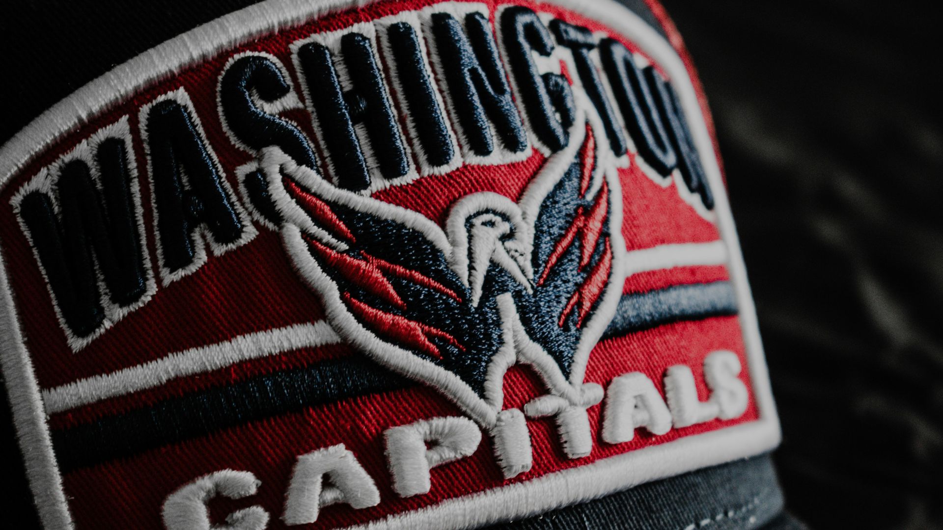 a black hat with a red and white logo on it