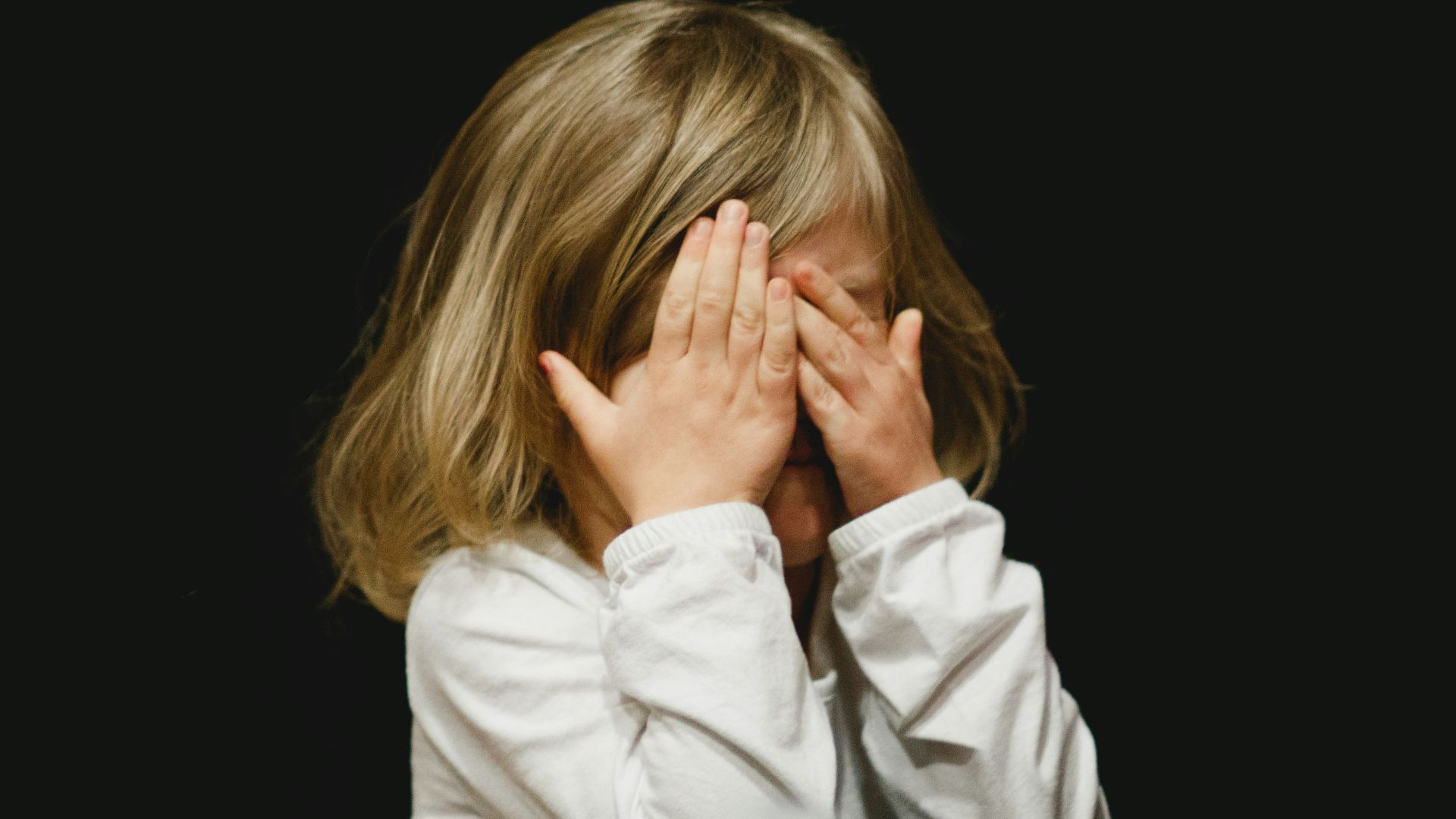 girl covering her face with both hands