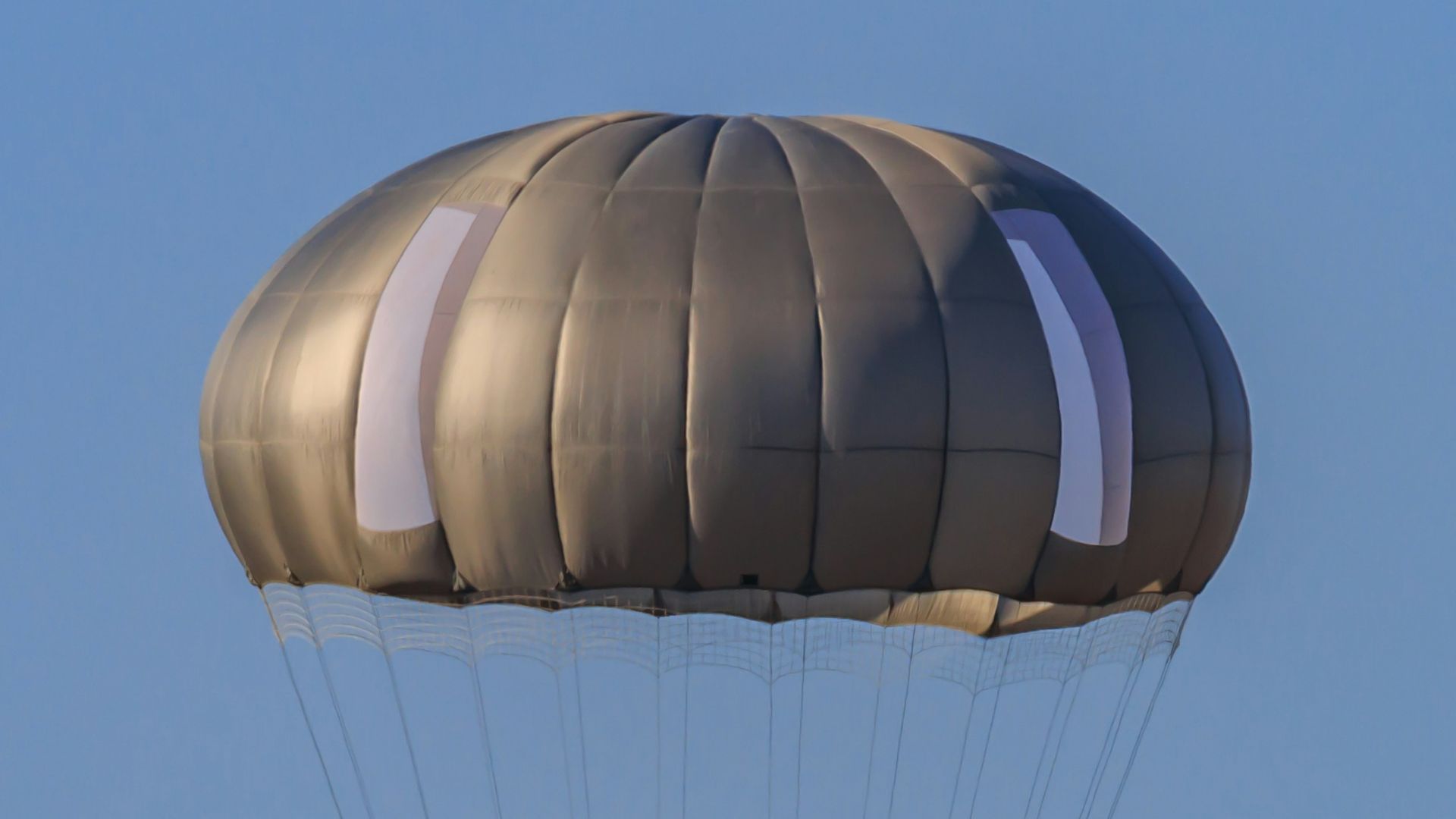 A man is parasailing in the blue sky