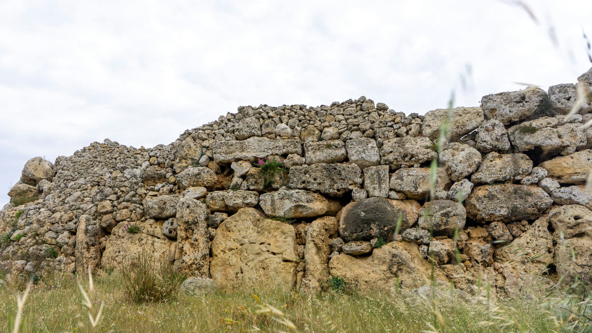a stone wall made of rocks and grass