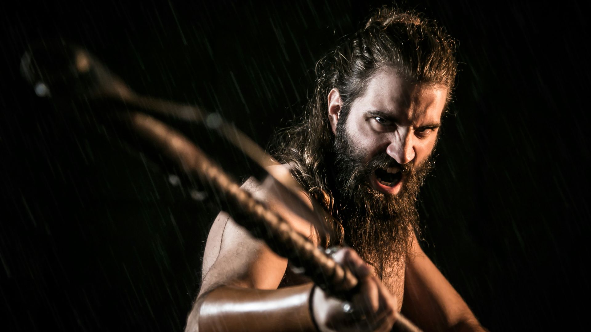 topless man holding black metal bar