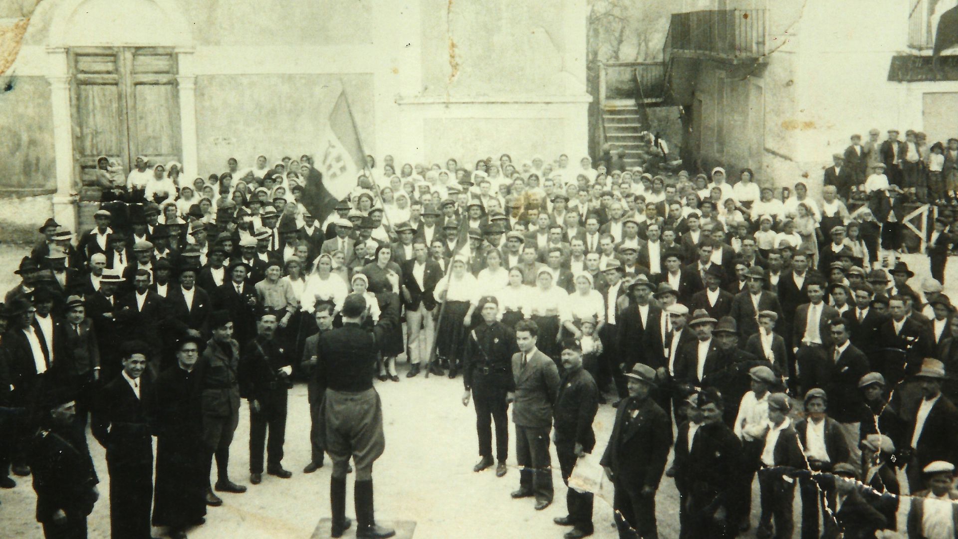 A man speaks to a large crowd outdoors