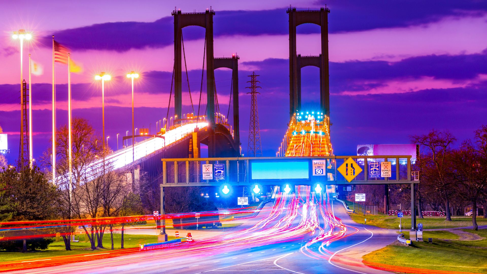 A city street at night with a bridge in the background