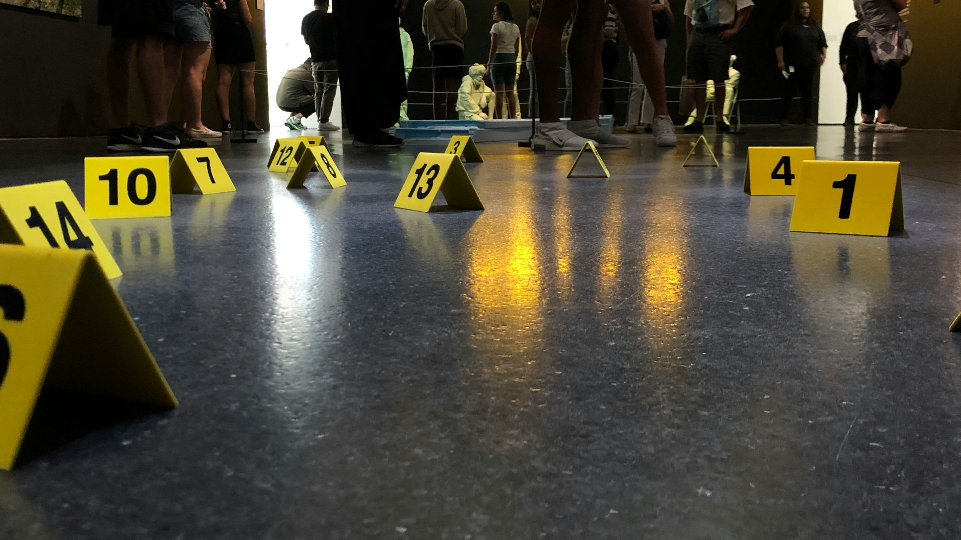 people sitting and standing inside building with numbers on floor