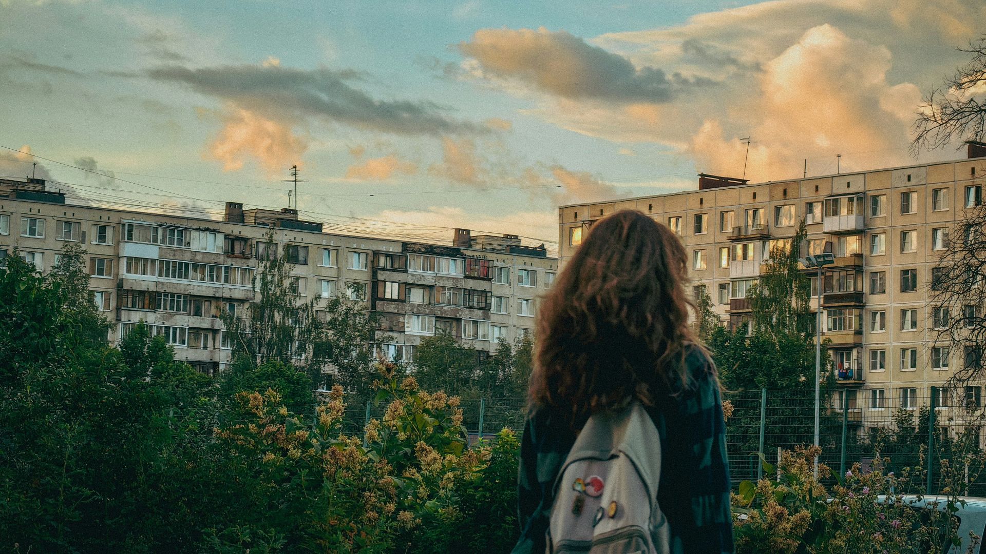 a woman with a backpack looks out over a city