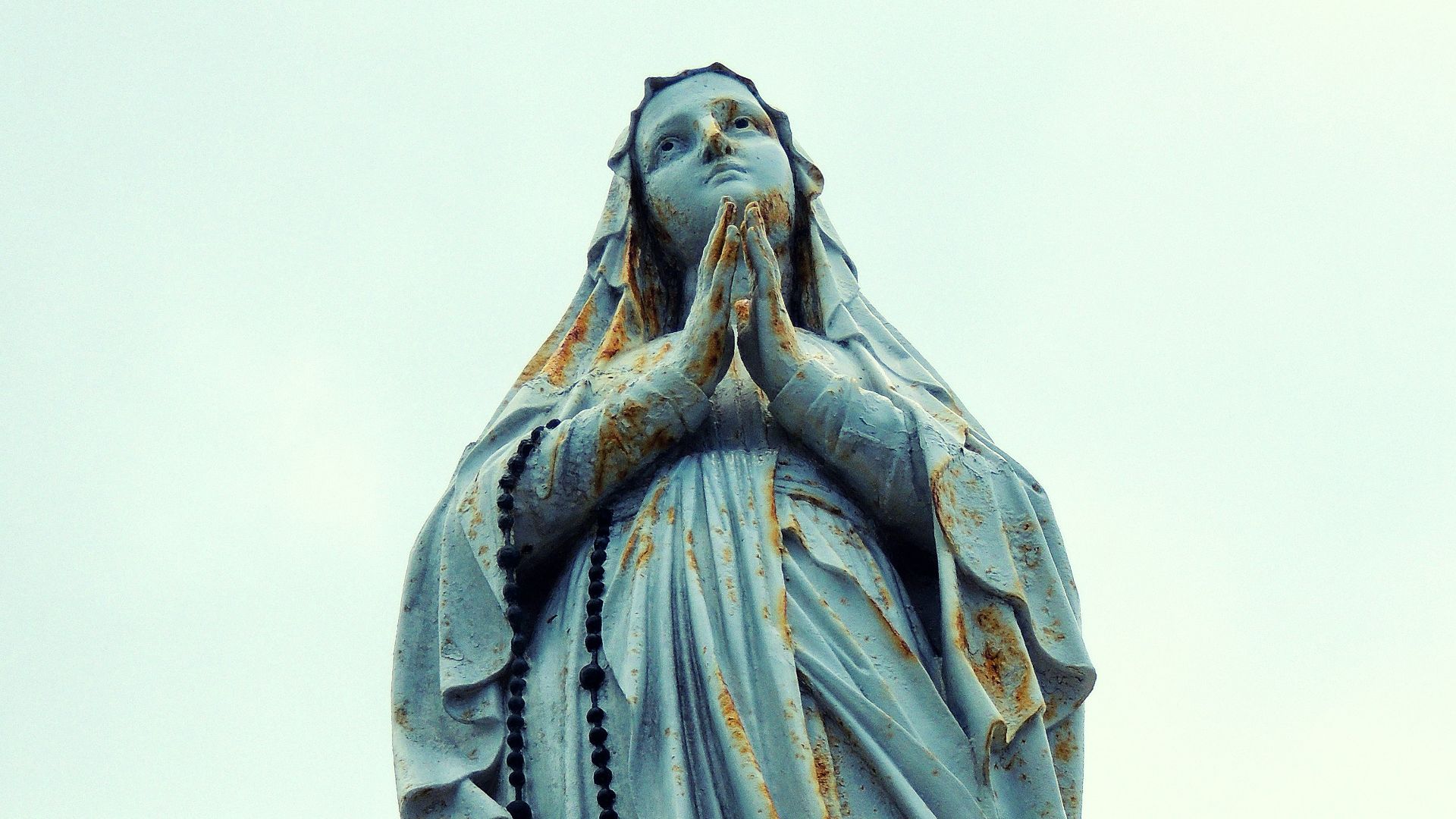 a statue of a woman holding her hands to her face