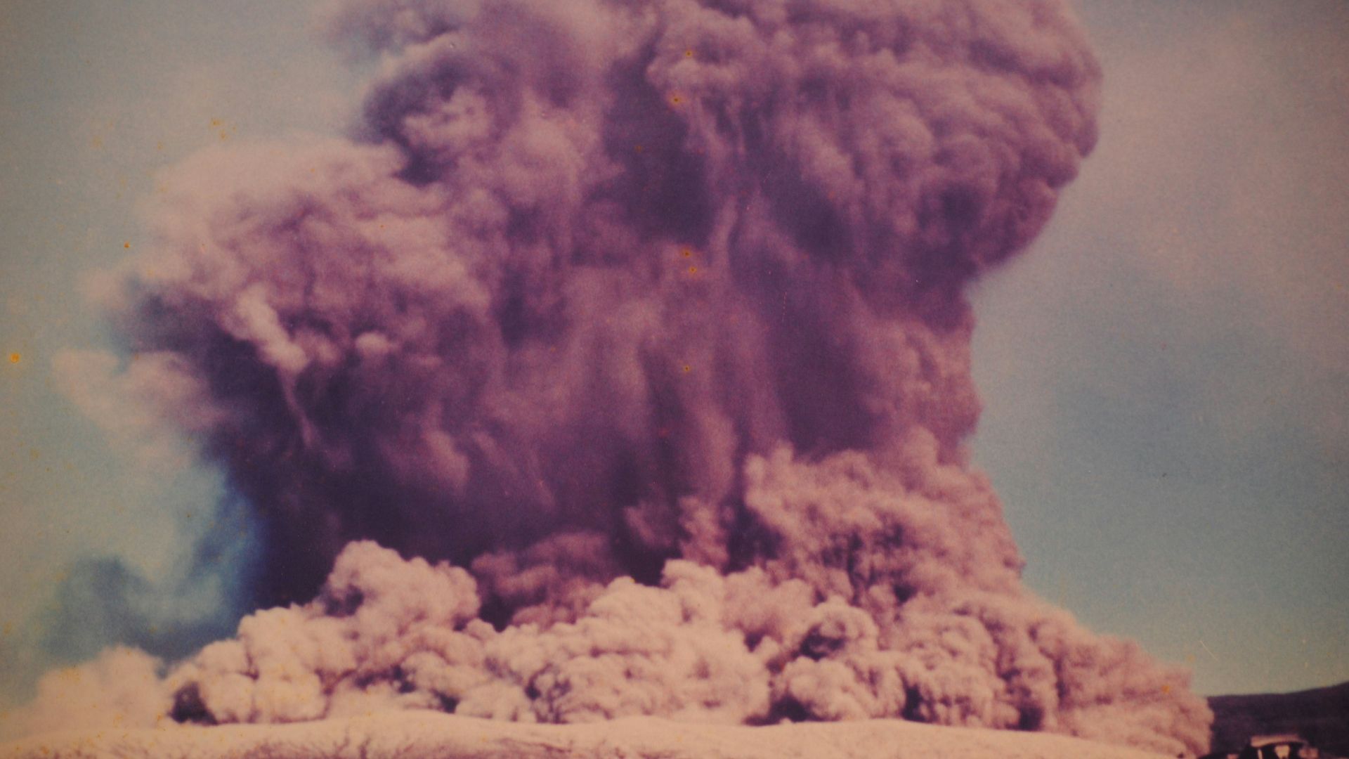 A massive plume of smoke rises skyward.