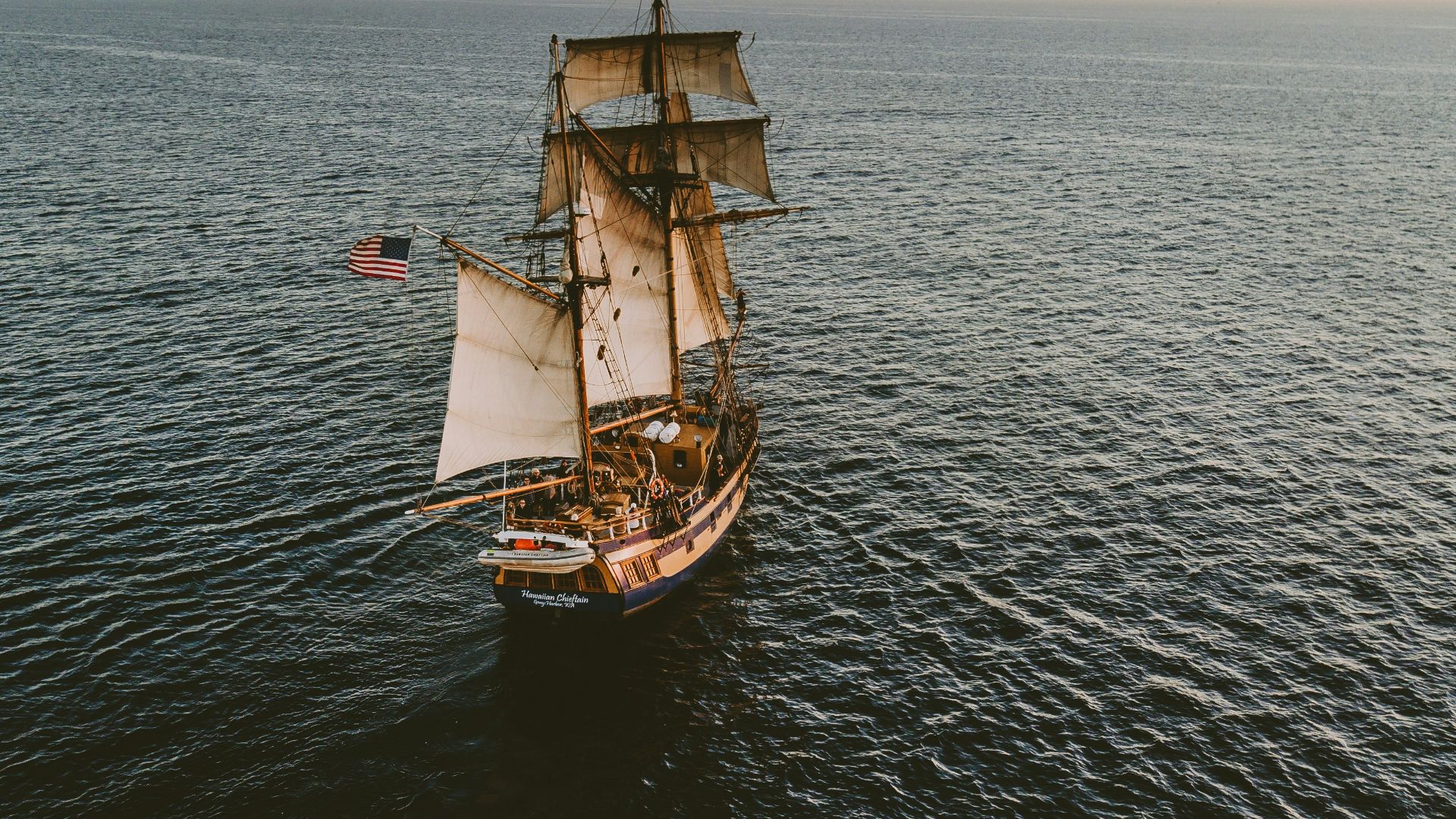 brown sailboat in beach under white sky