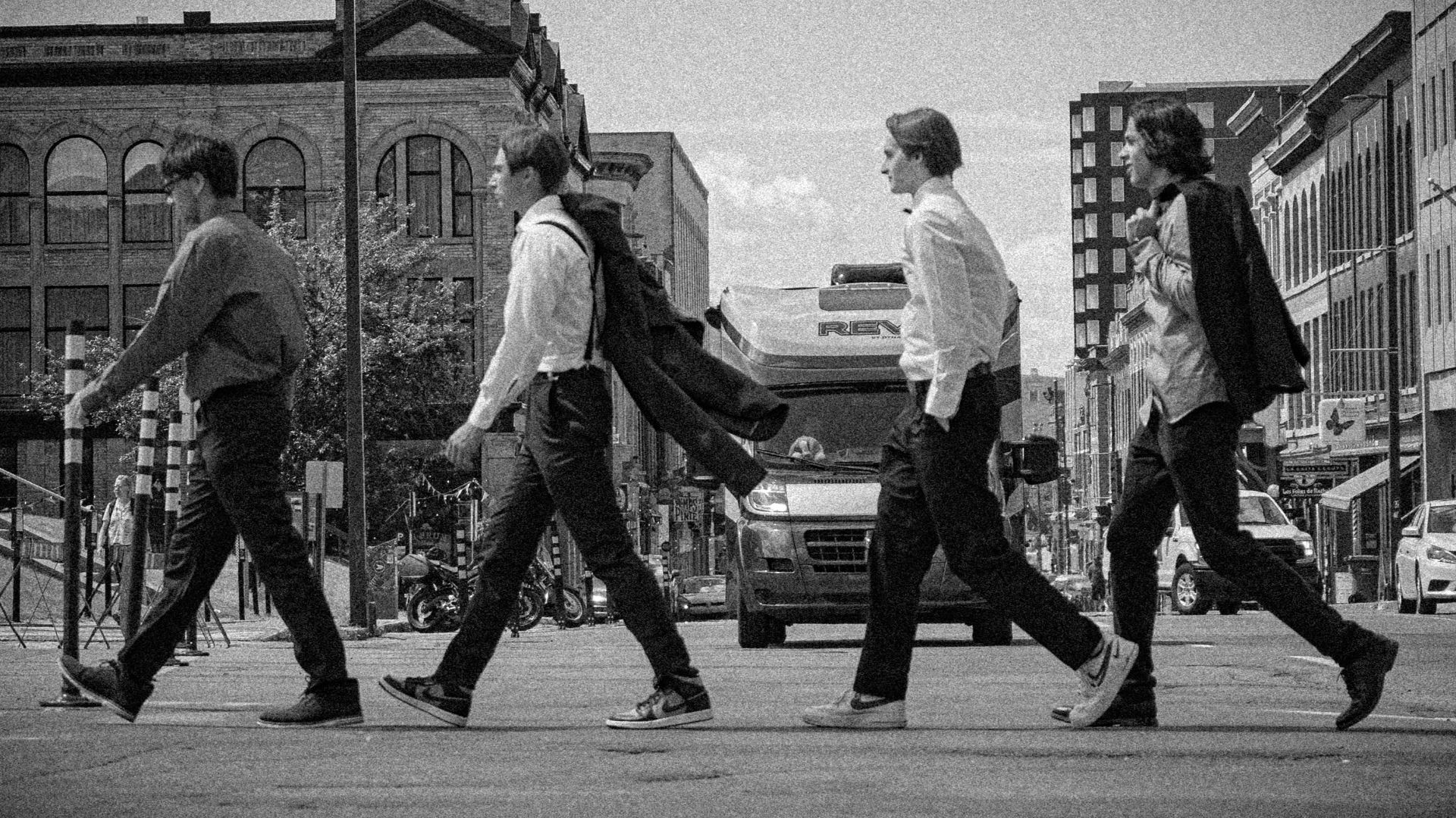 a group of men walking across a street