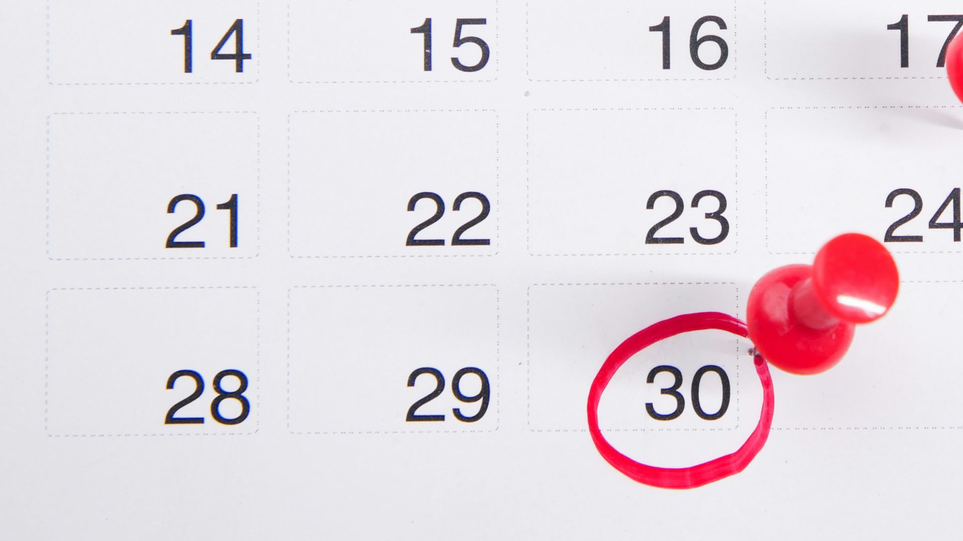 a calendar with red push buttons pinned to it