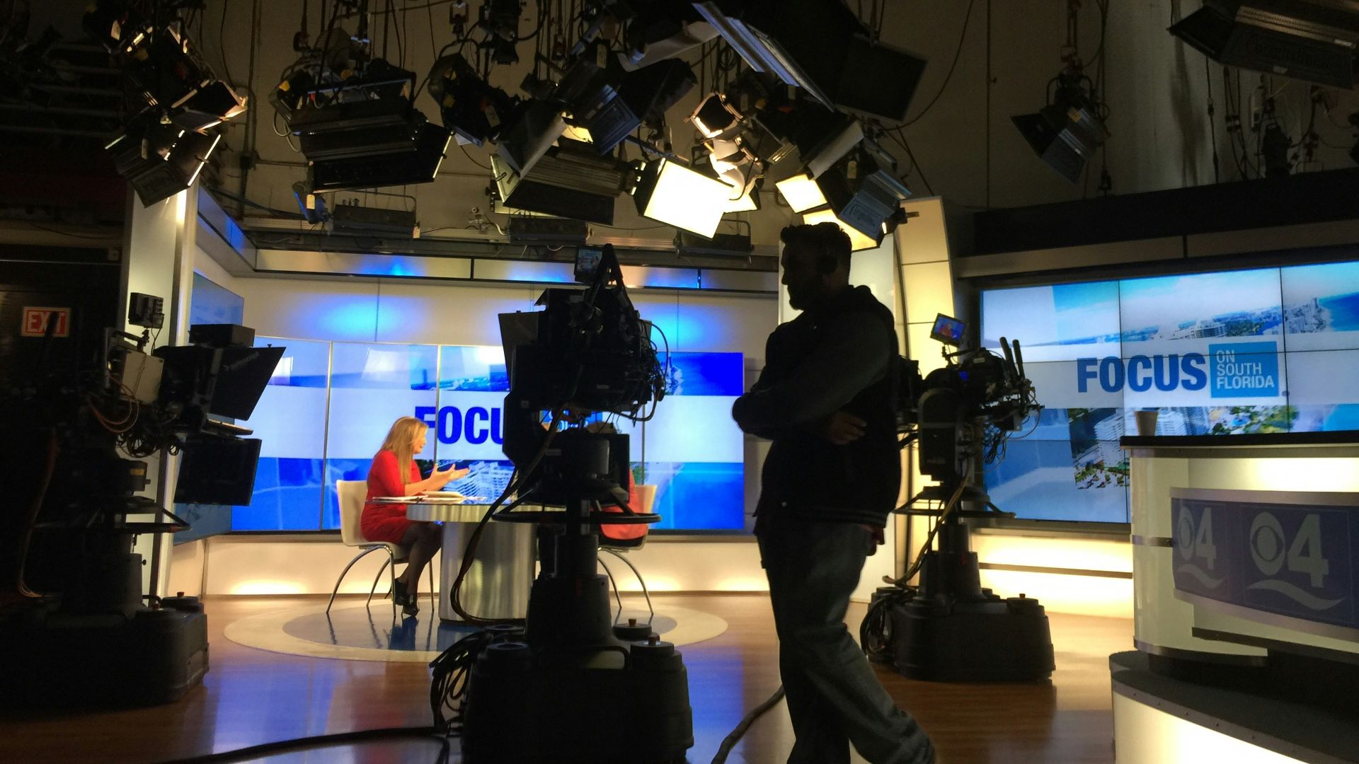man in black suit standing on stage