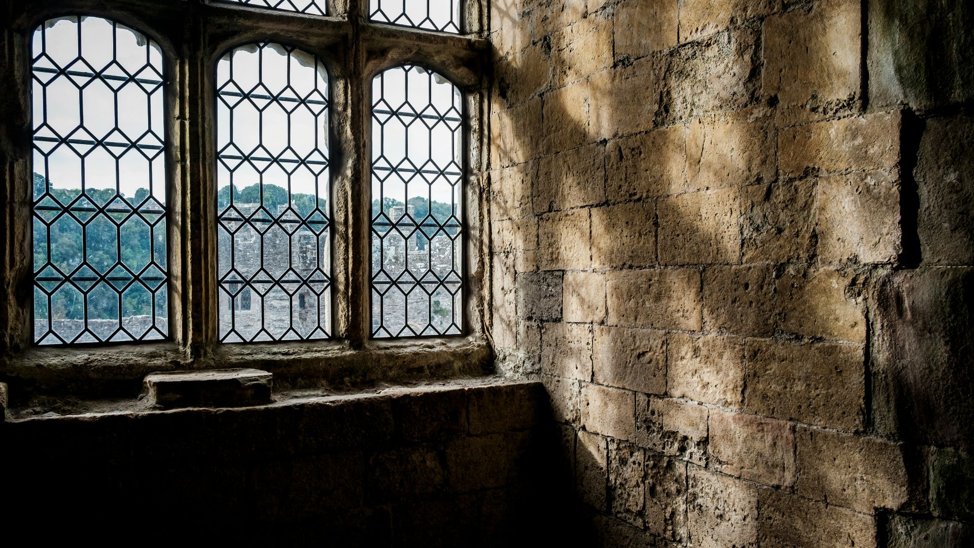 a window in a stone building with a view of a city