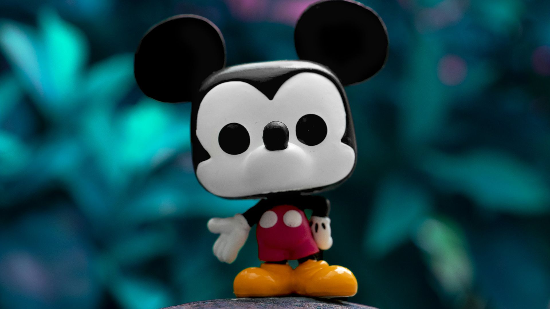 mickey mouse plush toy on gray rock