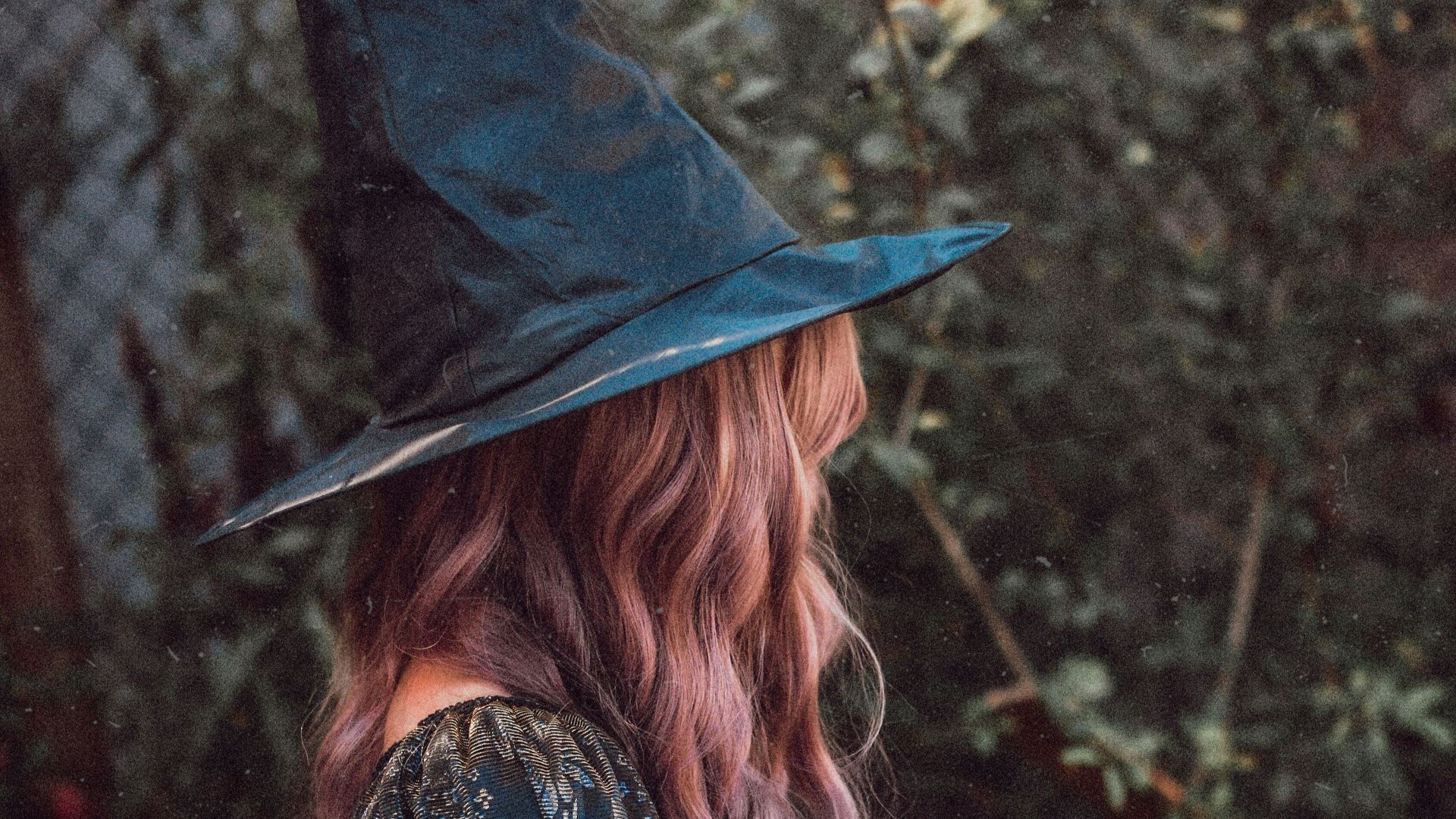 woman in black hat and brown dress holding pumpkin