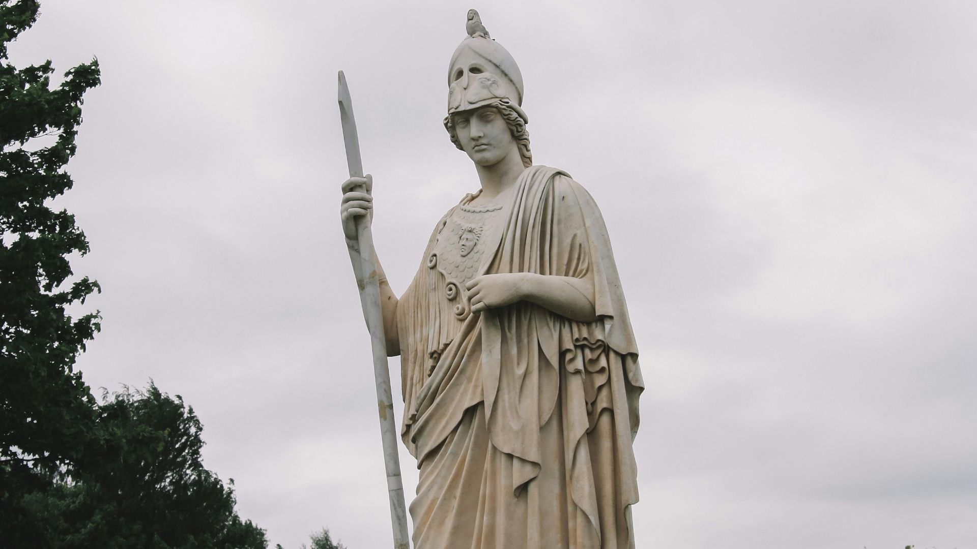 gold statue of man holding sword