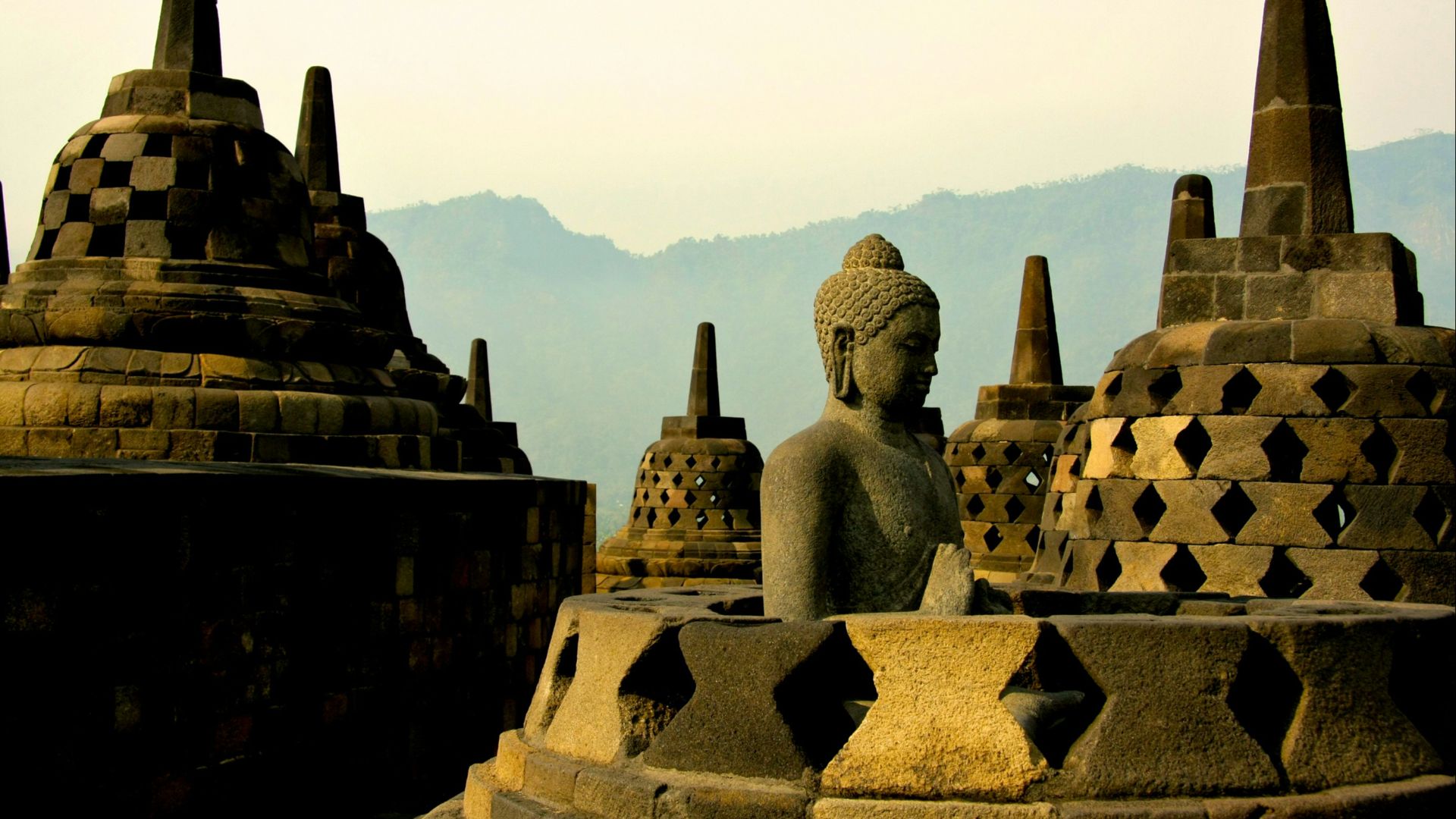 gold buddha statue on top of white and brown concrete building during daytime