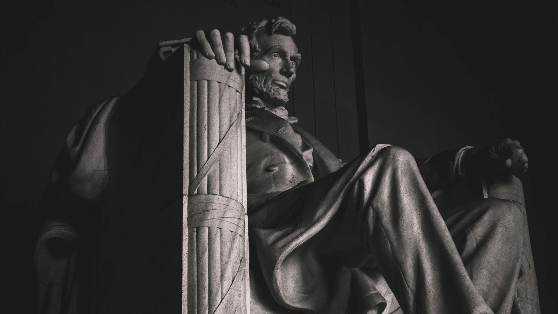 man in robe statue in grayscale photography