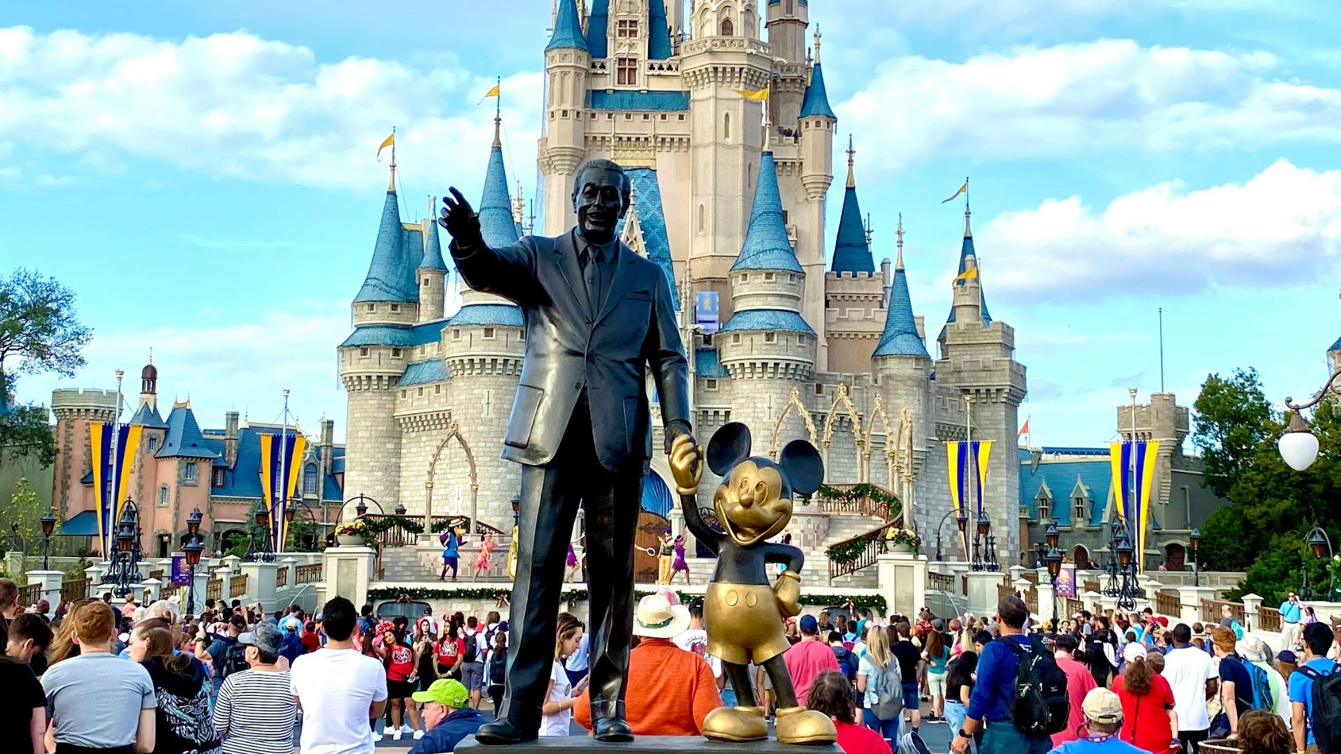 people walking on park near disney castle during daytime