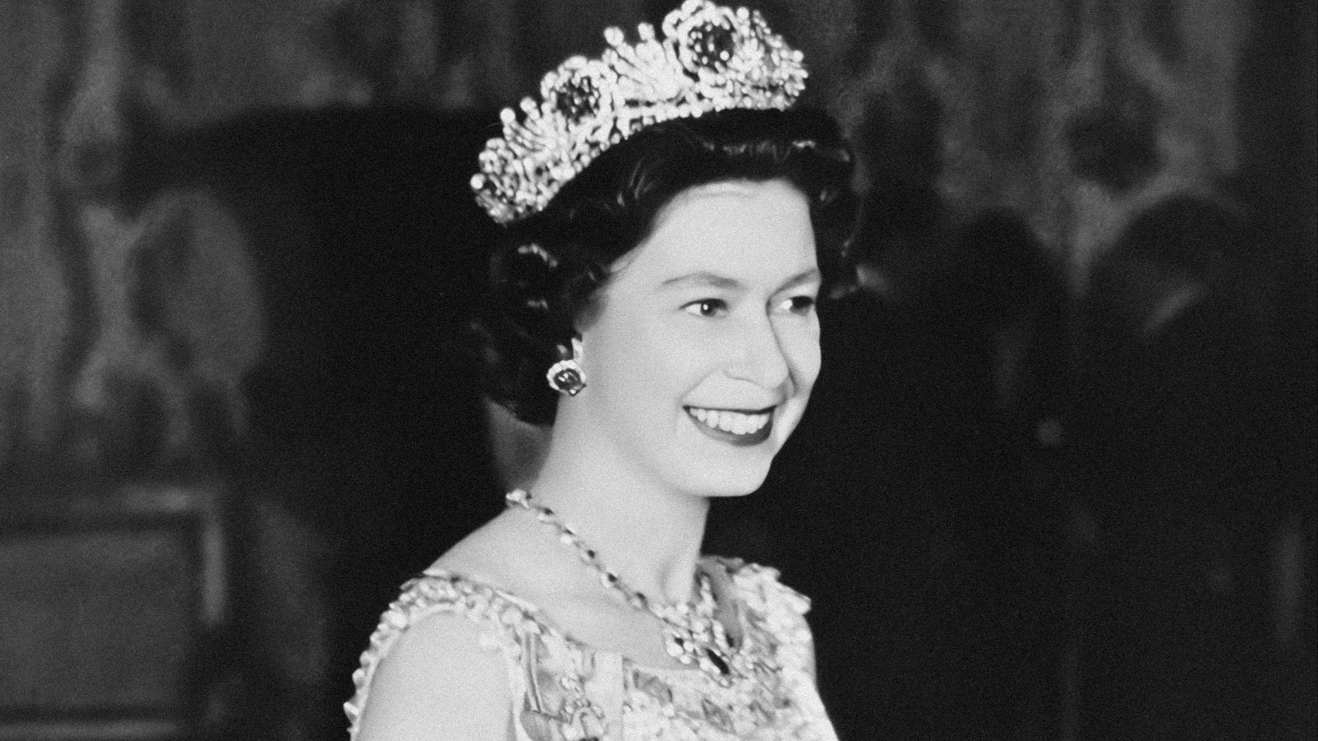 a black and white photo of a woman wearing a tiara