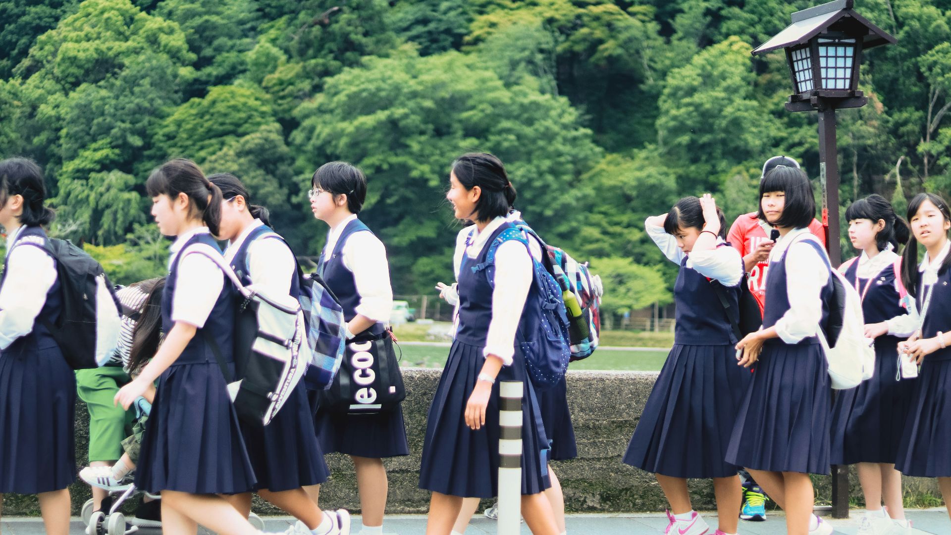 group of women in school uniform standing on green grass field during daytime